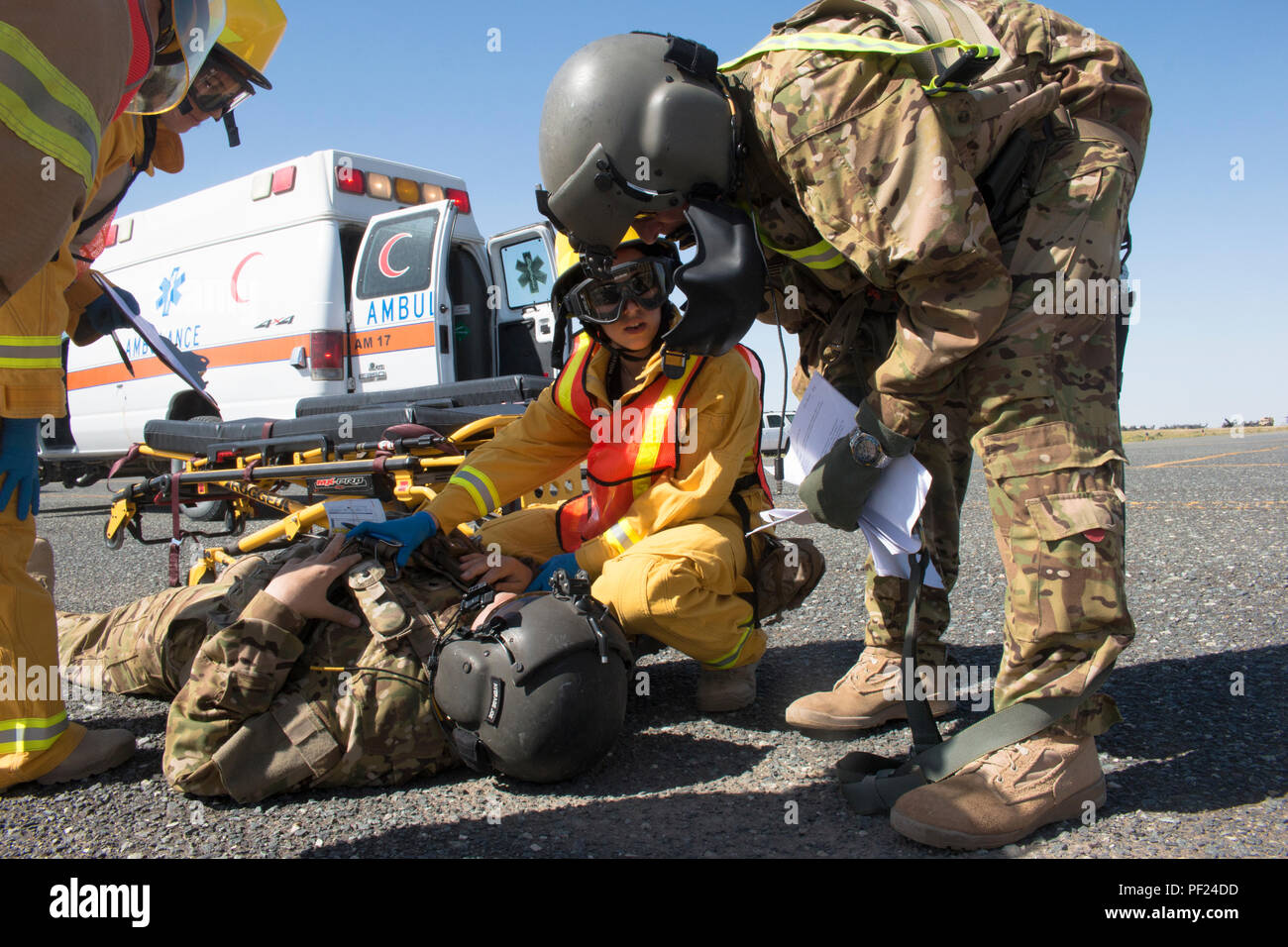 Paramedic T.J. Holliday (center) discusses a simulated patient with California Army National Guard Lt. Col. Jim Brinkman, the brigade surgeon in Headquarters and Headquarters Company, 40th Combat Aviation Brigade during a pre-accident plan exercise at Camp Buehring, Kuwait, Feb. 24. A pre-accident plan prepares military and civilian agencies to work together in the event of an emergency situation. (U.S. Army Photo by Staff Sgt. Ian M. Kummer, 40th Combat Aviation Brigade Public Affairs) Stock Photo