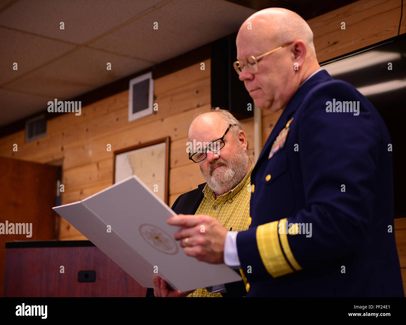 Bo Shindler is presented a Meritorious Public Service Award by Rear Adm. Richard Gromlich, commander Coast Guard 13th District, during an awards ceremony at Coast Guard Station Chetco River in Brookings, Ore., Feb. 29, 2016. Shindler was recognized for his efforts in rescuing two girls near the intersection of the Rogue and Illinois River in August 2015. (U.S. Coast Guard photo by Petty Officer 1st Class Levi Read) Stock Photo