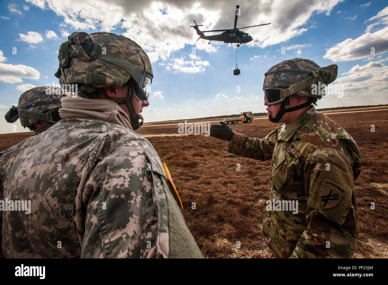 Staff Sgt. Robert Hames, left, sling load team leader, discusses training procedures with Pfc. Justin Kipperman, second from left, and Spc. Kevin Fletcher, all with the 404th Civil Affairs Battalion (Airborne), United States Army Reserve, during joint training at Coyle Drop Zone, Joint Base McGuire-Dix-Lakehurst, N.J., Feb. 29, 2016. (U.S. Air National Guard photo by Master Sgt. Mark C. Olsen/Released) Stock Photo