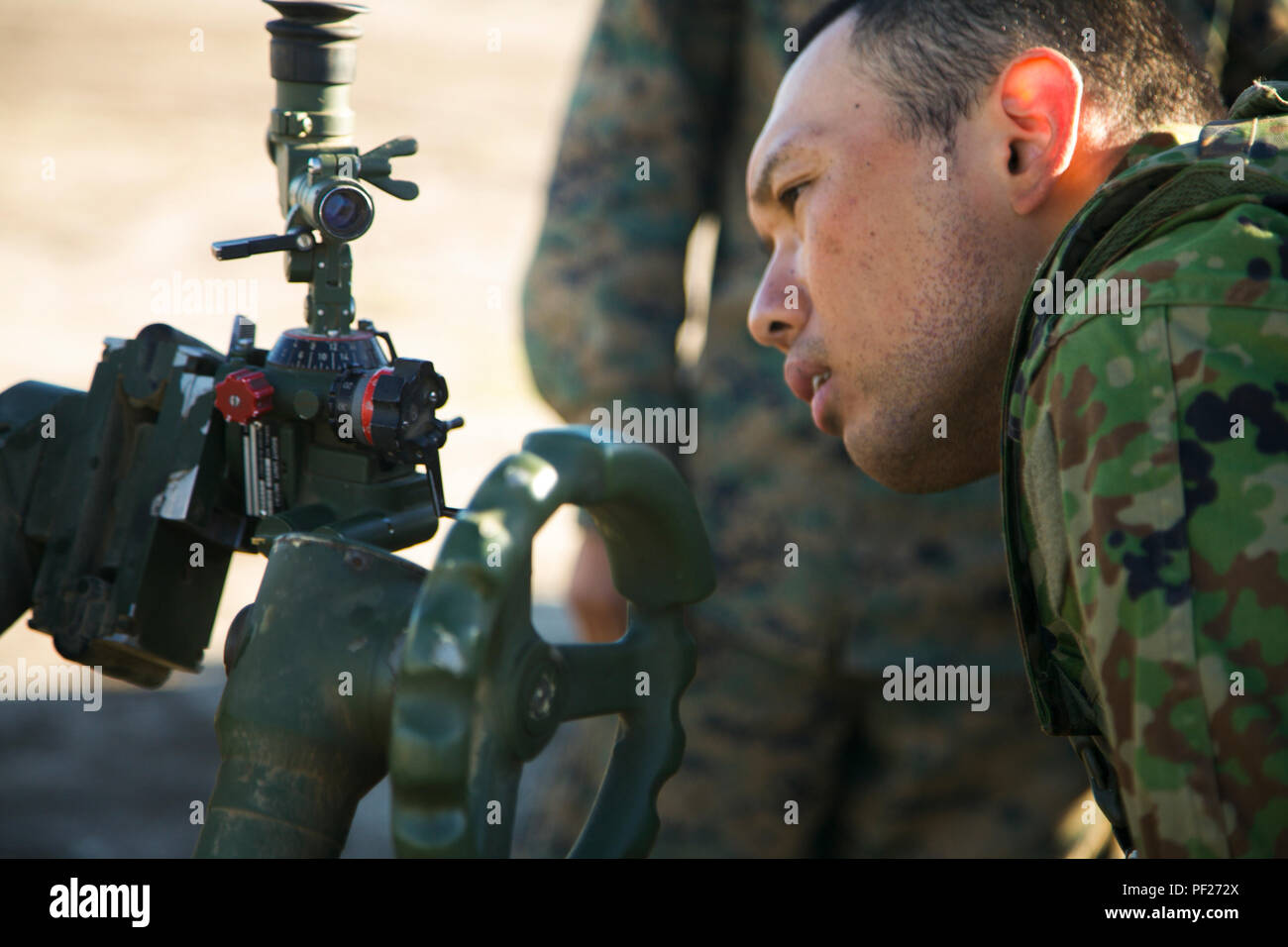 Western Army Infantry Regiment, Japan Ground Self-Defense Force, Sergeant Tatsuya Mateabara looks through a sight of a 120mm M327 Towed Rifled Mortar System during the Supporting Arms Coordinating Center Exercise (SACCEX) for Iron Fist 2016, aboard San Clemente Island, Calif., Feb. 21, 2016. SACCEX  serves as a cooperative learning tool for the US-Japan partnership through the operation of a SACC, which has developed the USMC and JGSDF’s ability to integrate naval gunfire, mortars and close-air support  as a combined force. (U.S. Marine Corps photo by Cpl. Xzavior T. McNeal/Released) Stock Photo