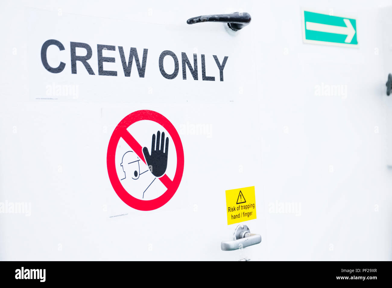 Crew only sign on white door onboard ferry cruise ship Stock Photo
