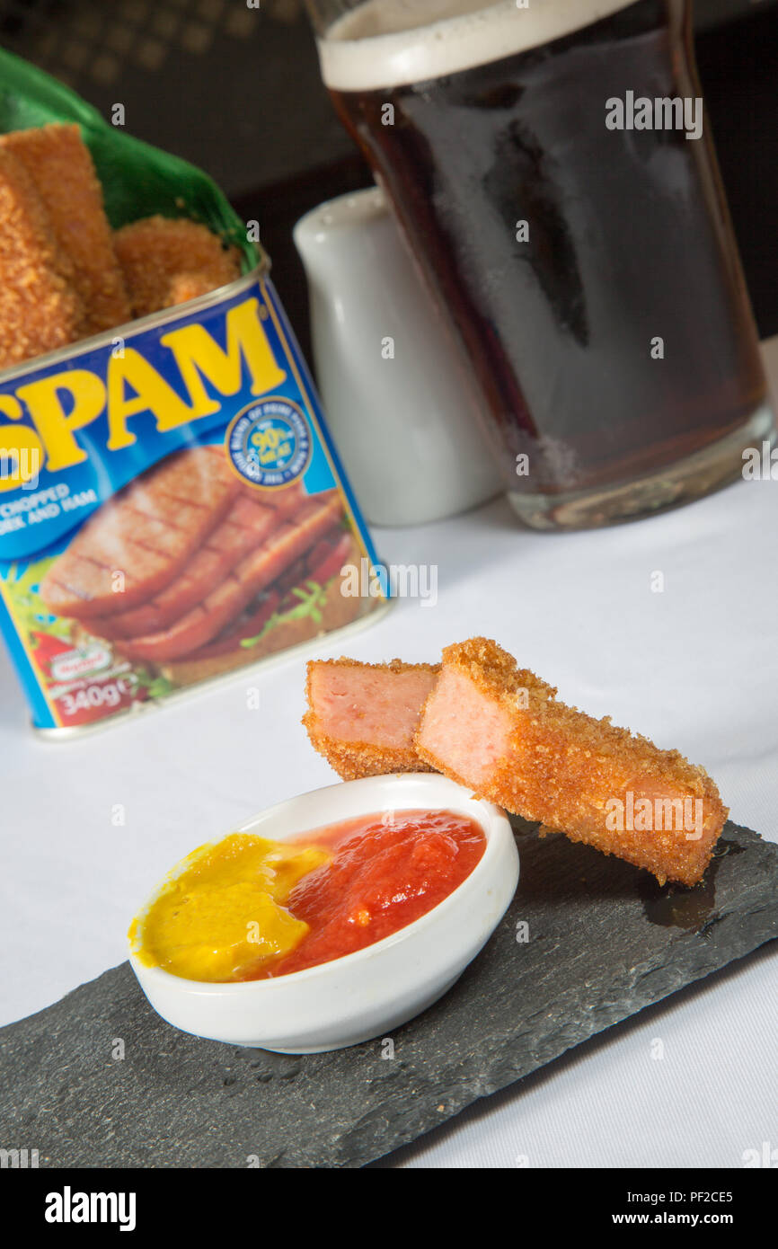 An English pub snack of Spam fingers in breadcrumbs, served in the Spam  can/tin with English mustard and ketchup Stock Photo - Alamy