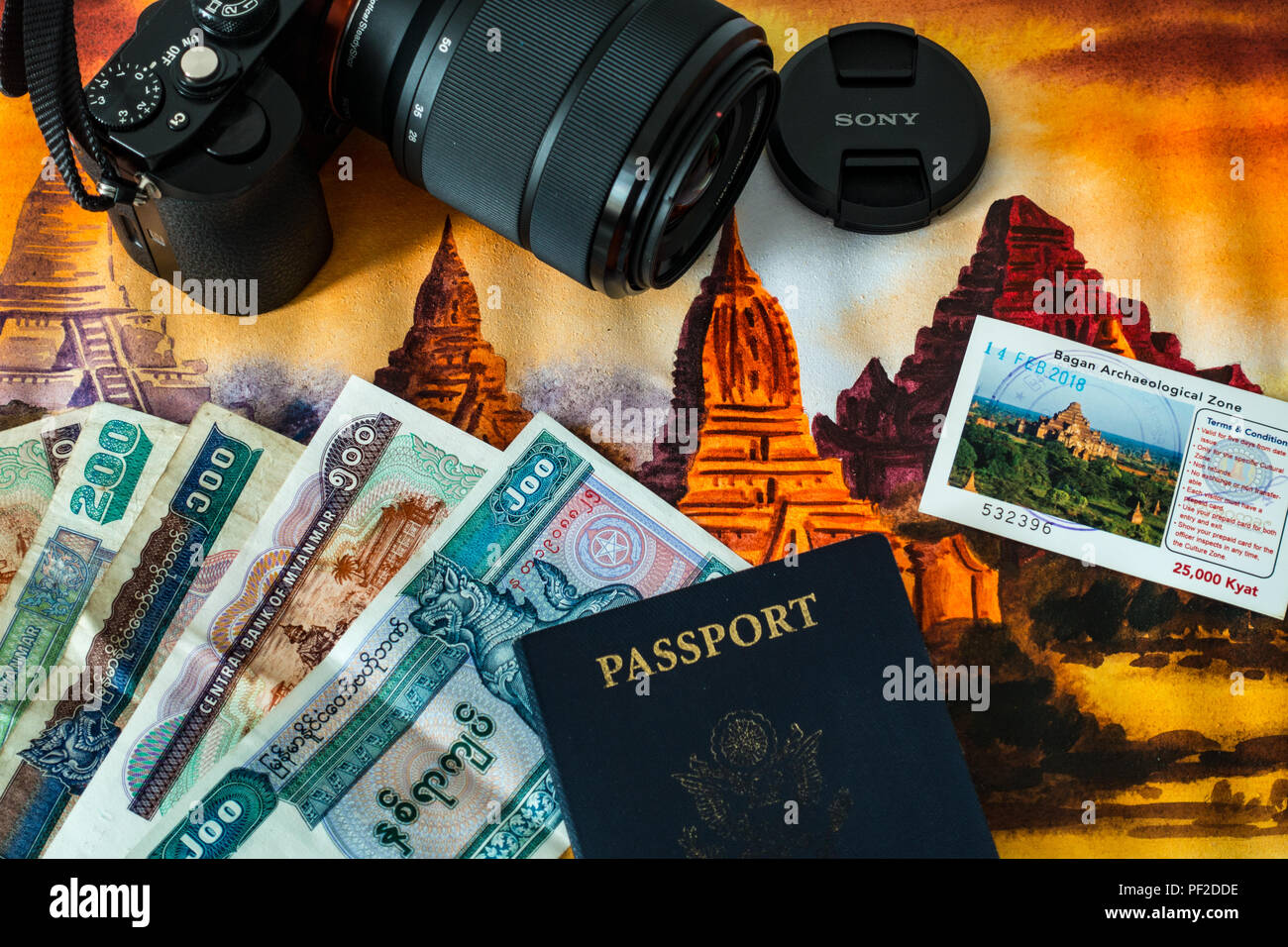 Myanmar travel concept with local currency, passport, camera, and painting of Bagan Stock Photo