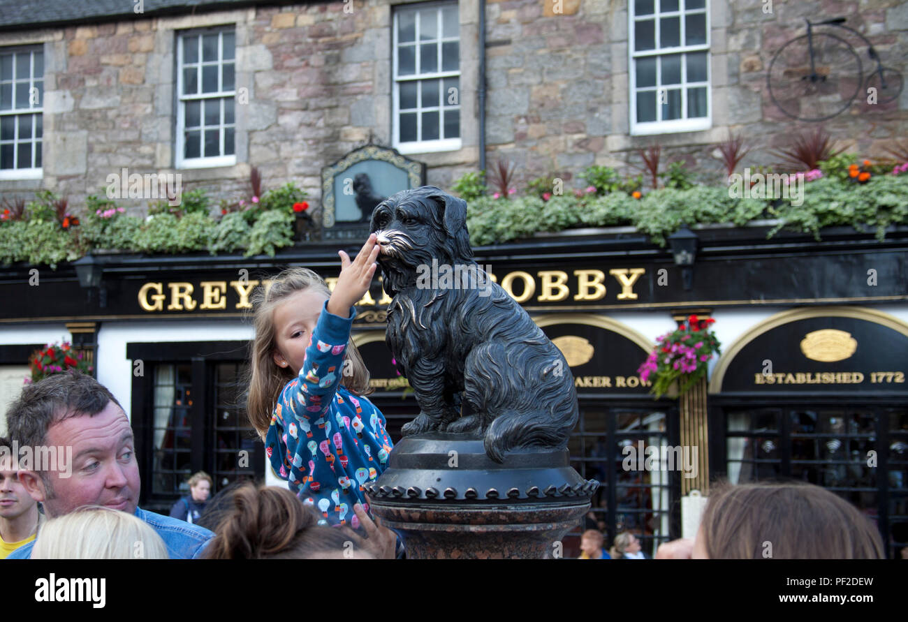 Greyfriar's Bobby with young girl rubbing worn nose, Edinburgh, Scotland UK, Stock Photo
