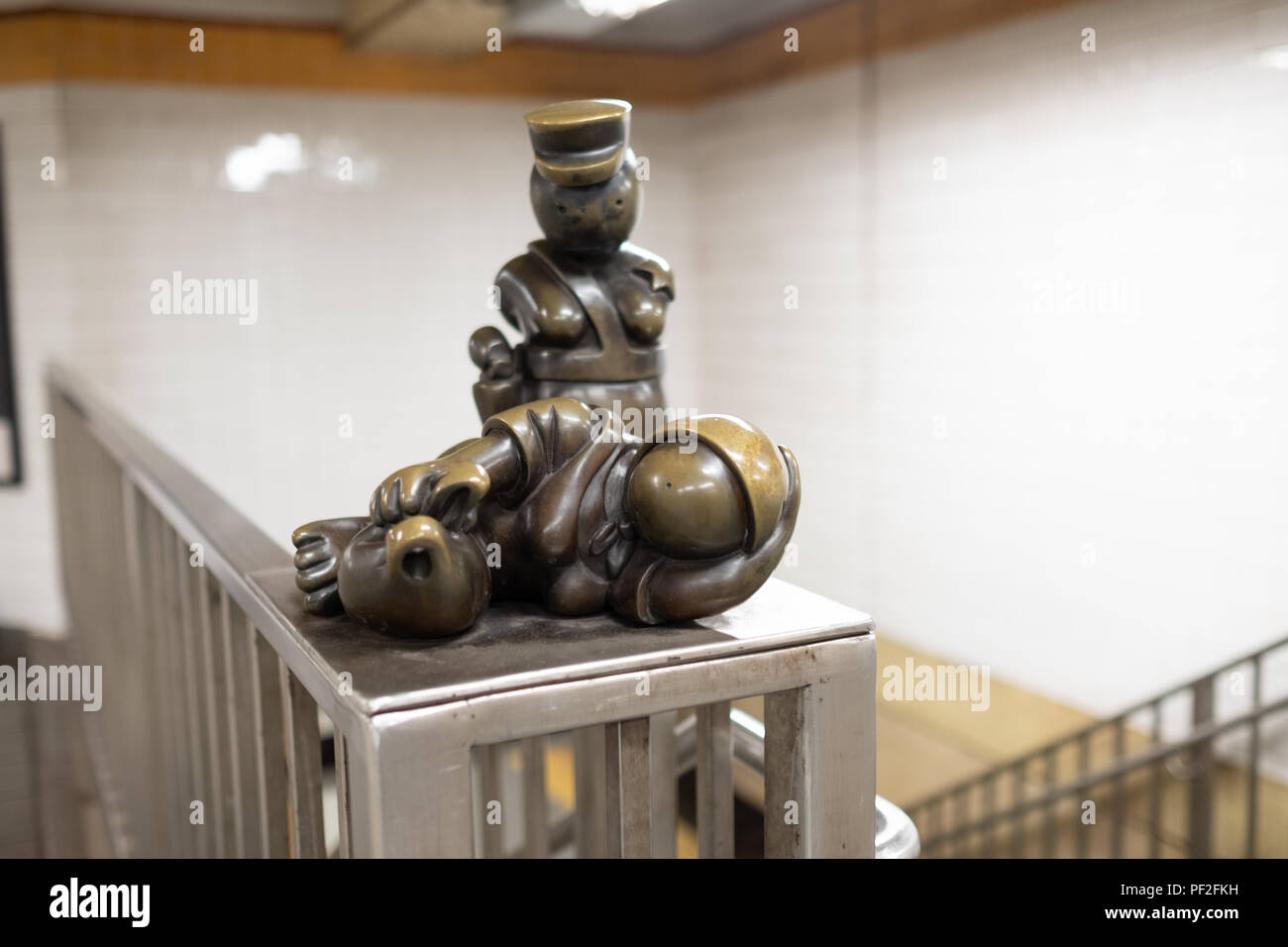 Sculpture Sleeping Homeless with Officer in Background at New Yorker Subway Stock Photo