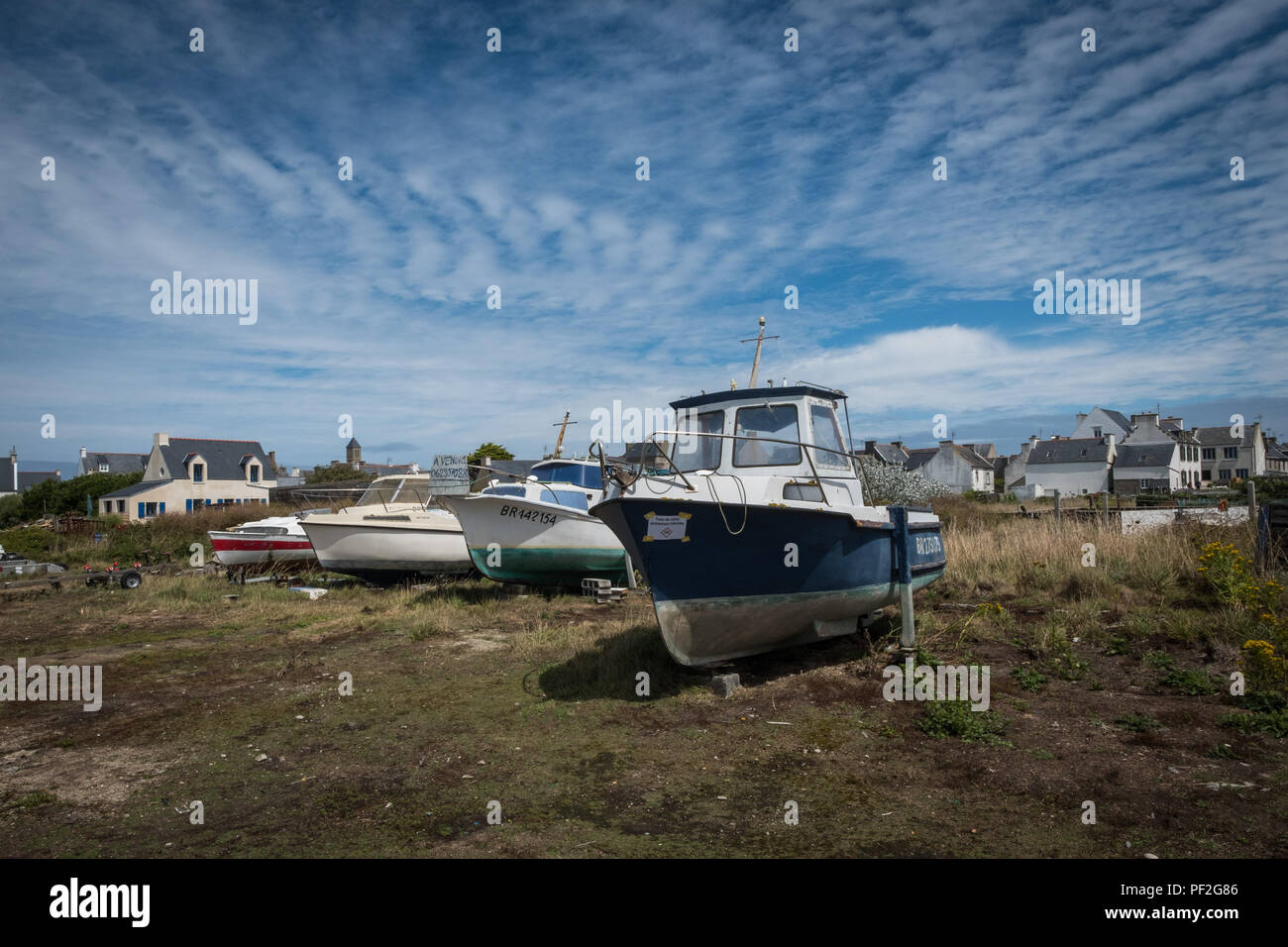 Boats on the ground on the island of Sein in Bretagne (France) with the dwellings in the background. Stock Photo