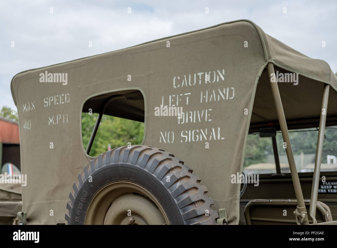 Rear view of an iconic, WW2 US Army Jeep showing the raised hood of this restored military vehicle. Information is seen printed on the hood's rear. Stock Photo