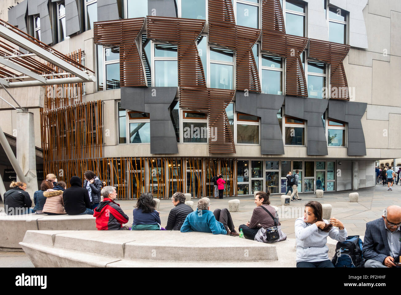 Tourists and visitors relaxing outside the Scottish Parliament building in Edinburgh, Scotland. Stock Photo