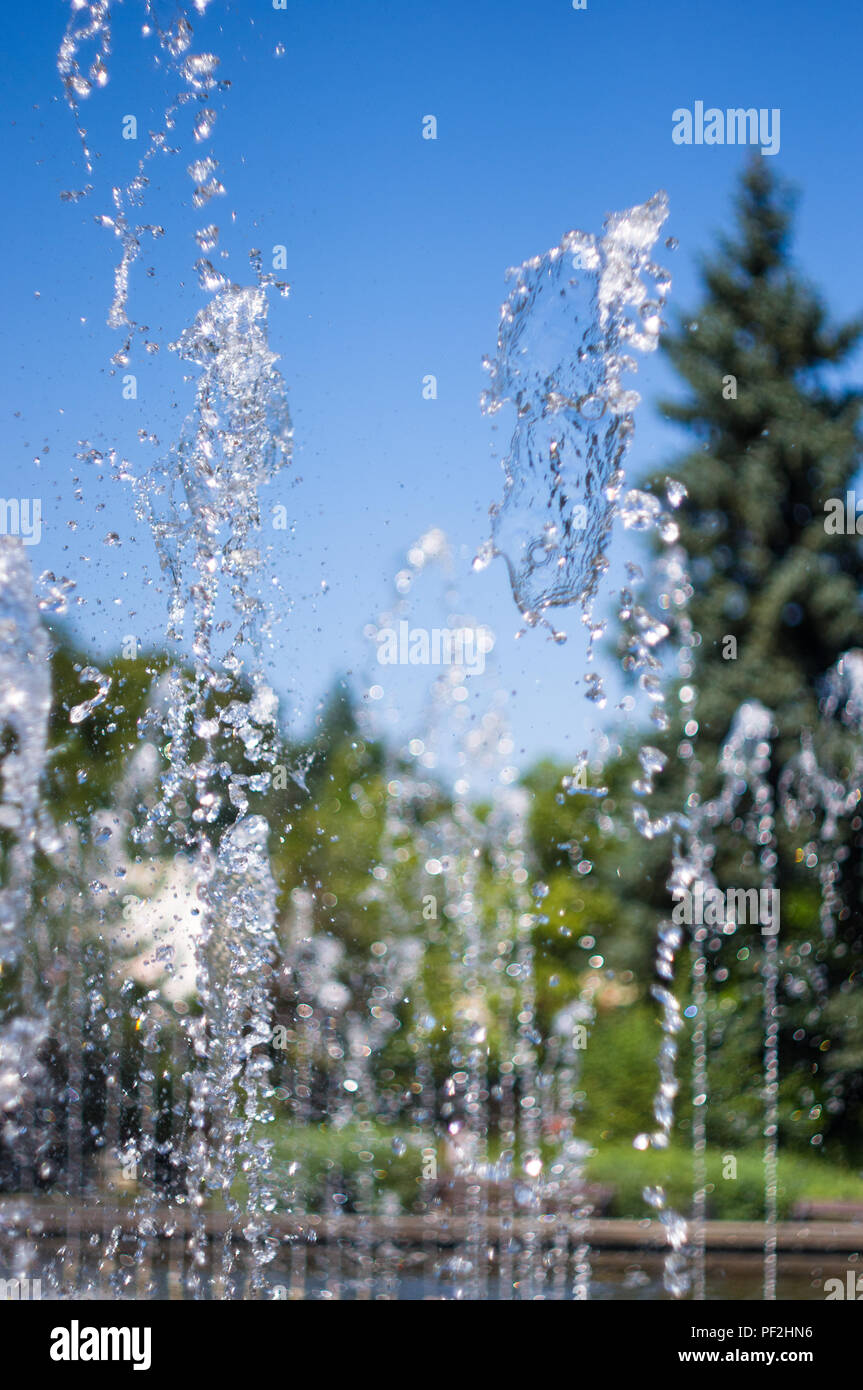 Fountain in city park on hot summer day, beautiful bright streams of