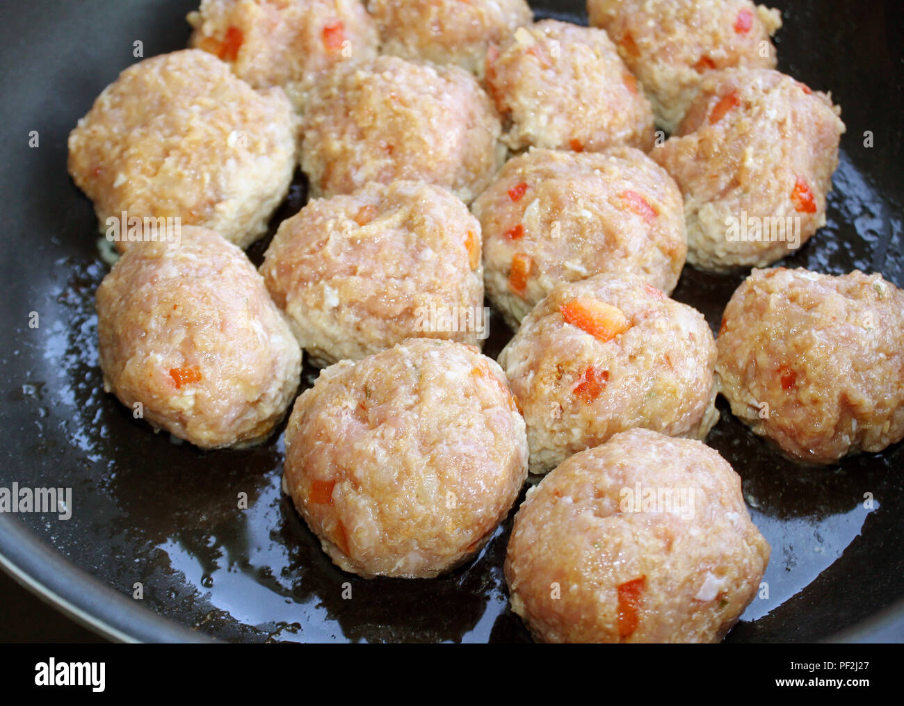 Lean ground turkey meatballs cooking in skillet Stock Photo