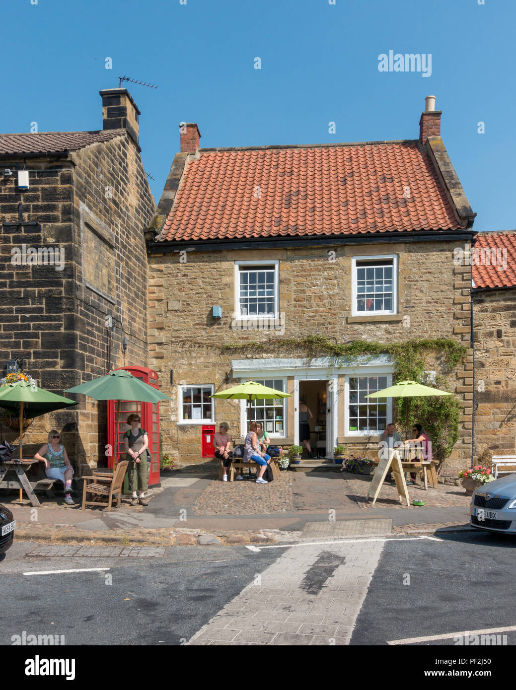 People sit outside the cafe 'Osmotherley Tea and Coffee Shop' North York Moors in hot weather
