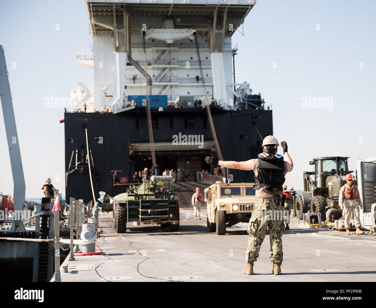 Sailors attached to Amphibious Construction Battalions 1 and 2 guide an ...