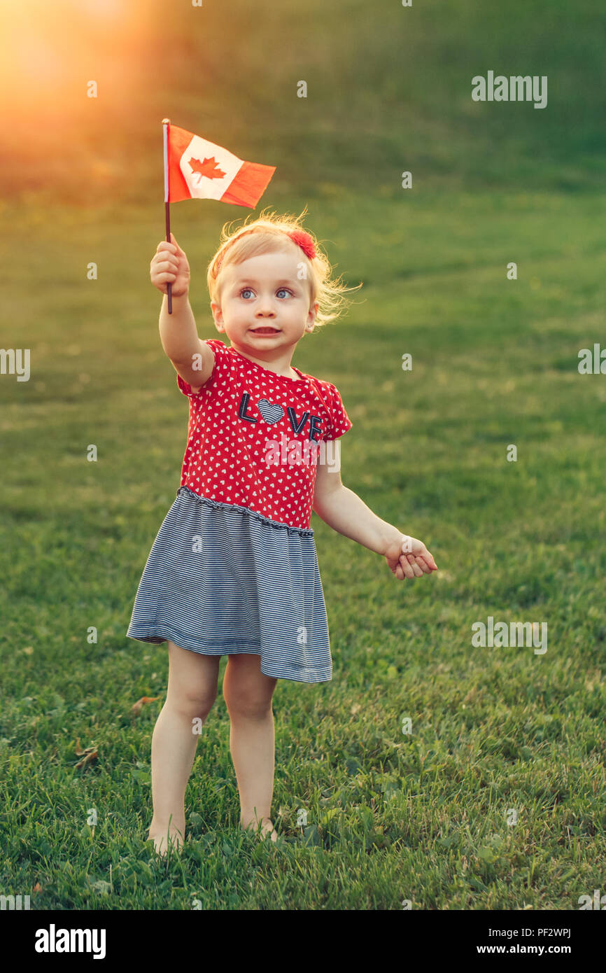 Portrait Of Adorable Cute Littleblonde Caucasian Baby Toddler Girl   Portrait Of Adorable Cute Littleblonde Caucasian Baby Toddler Girl Holding Waving Canadian Flag Female Child Citizen Celebrating Canada Day PF2WPJ 