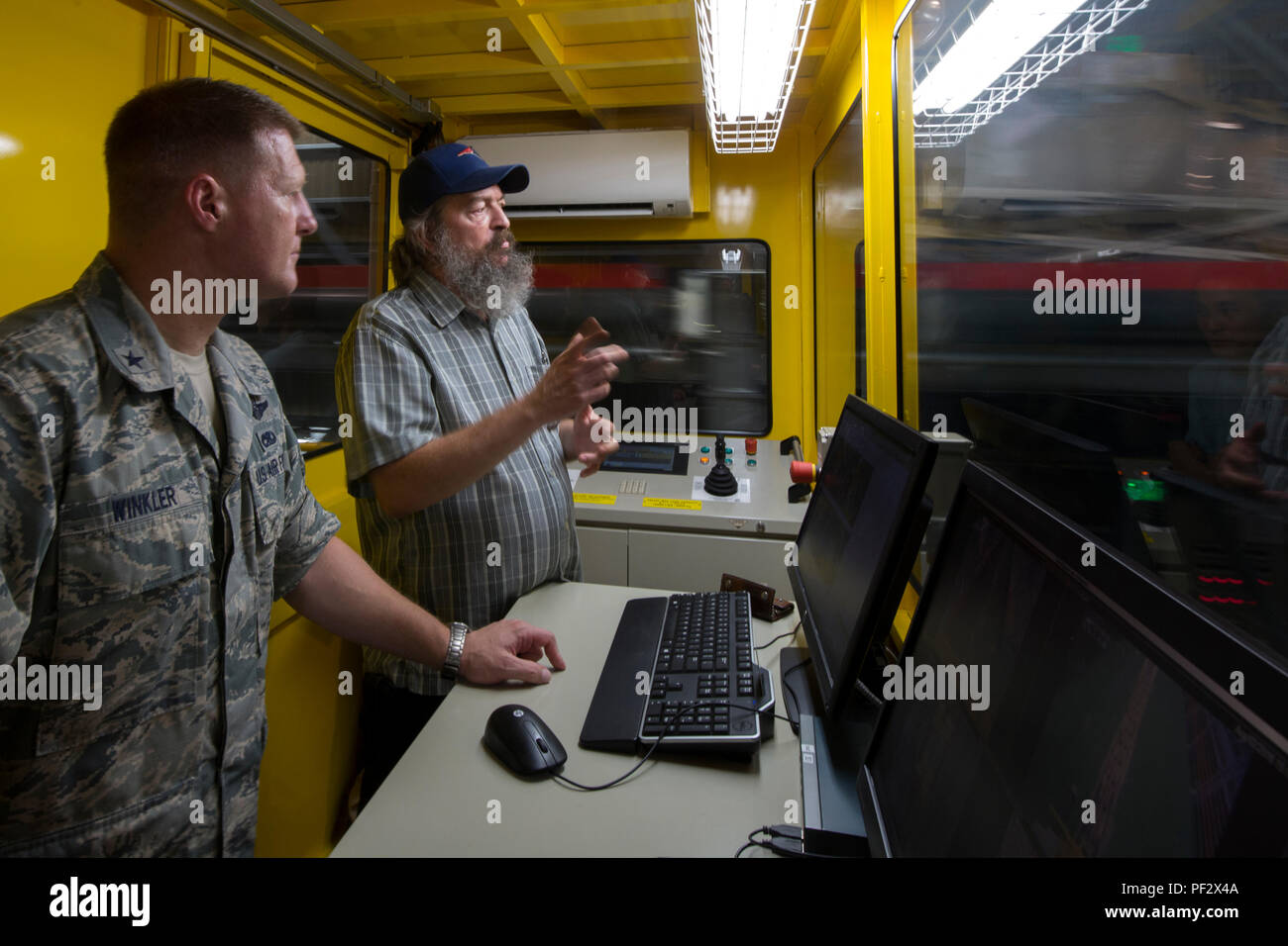Brig. Gen. Michael Winkler, 5th Air Force vice commander, is briefed by Dean Labdon, 730th Air Mobility Squadron mechanized material handling system manager, on the MMHS capabilities at Yokota Air Base, Japan, Aug. 2, 2016, during his immersion tour. The automated system sorts, records and stores pallets in the warehouse based on their destination. (U.S. Air Force photo by Yasuo Osakabe/Released) Stock Photo