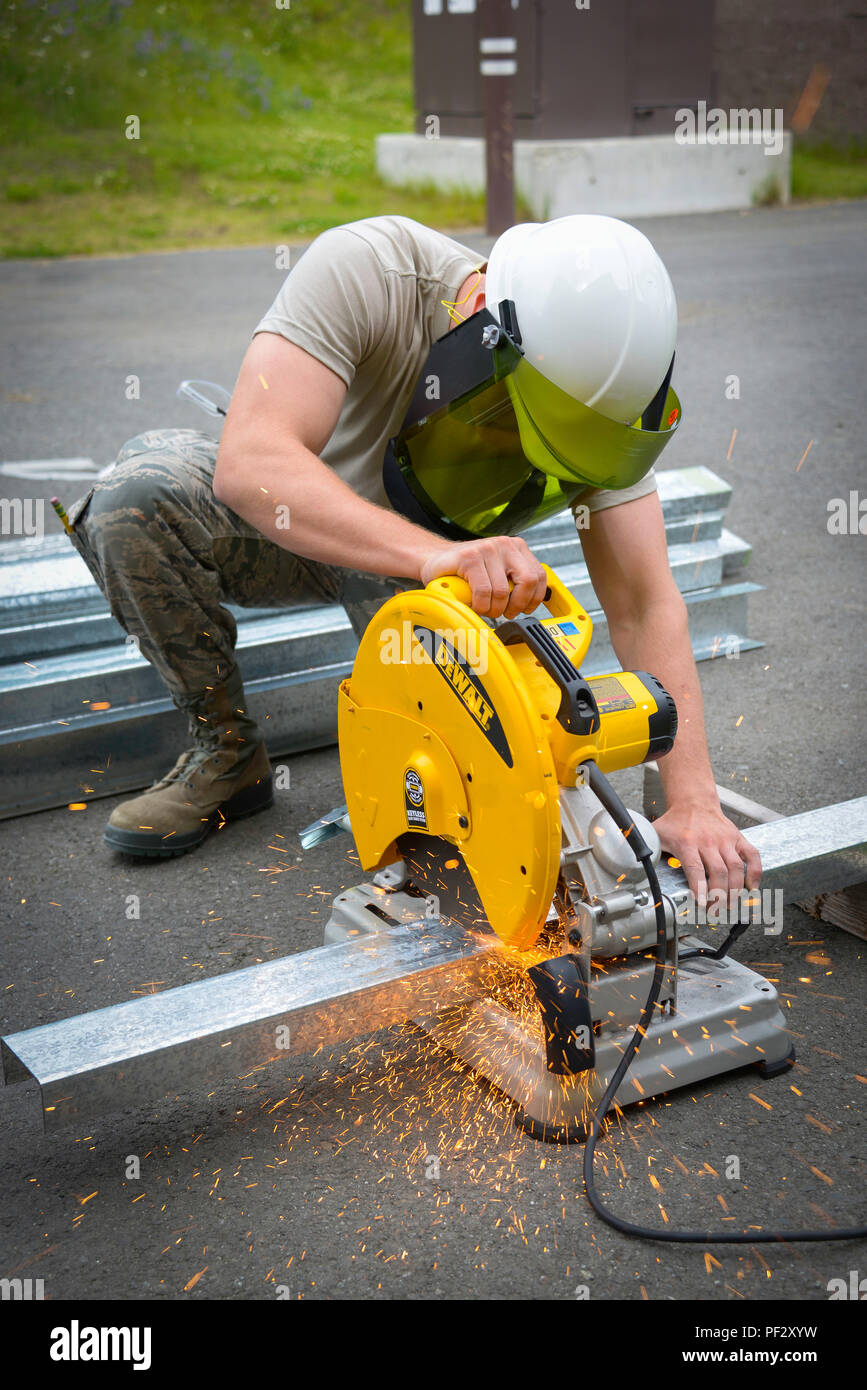 Senior Airmen Robert Behan with the 134th Air Refueling Wing Civil Engineer Squadron cuts a metal stud used for framing during their deployed field training. The 134th CES deployed to Joint Base Elmendorf-Richardson, AK to supplement deployed personnel and complete annual training requirements, July 25, 2017. (U.S. Air National Guard Photo by Staff Sgt. Ben Mellon) Stock Photo