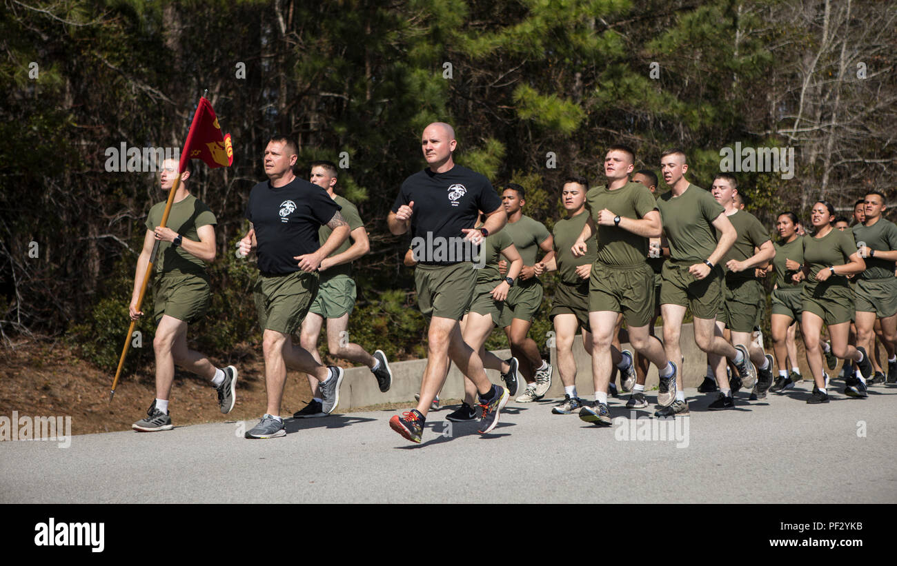 U.S. Marine Corps 1st Sgt. Bradley J. Kretzing, center, senior enlisted advisor, and Lt. Col. Casey L. Taylor, commanding officer, both assigned to Personnel Administration School, Marine Corps Combat Service Support Schools lead their Marines on a command run at Camp Johnson, N.C., Feb. 23, 2018. The purpose of the command run was to build unit cohesion, physical fitness and camaraderie. (U.S. Marine Corps photo by Lance Cpl. Tyler Pender) Stock Photo