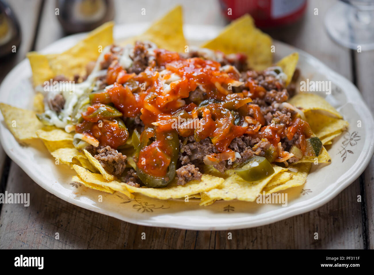 Chilli beef nachos with salsa, jalapeños & grated cheese Stock Photo