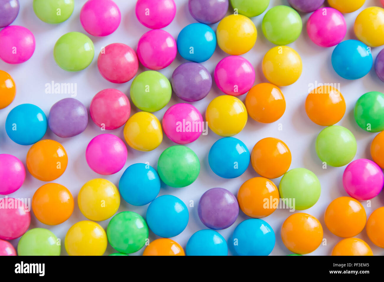 Pile of colorful sweet candy chocolates coated on white paper. colourful collection Stock Photo