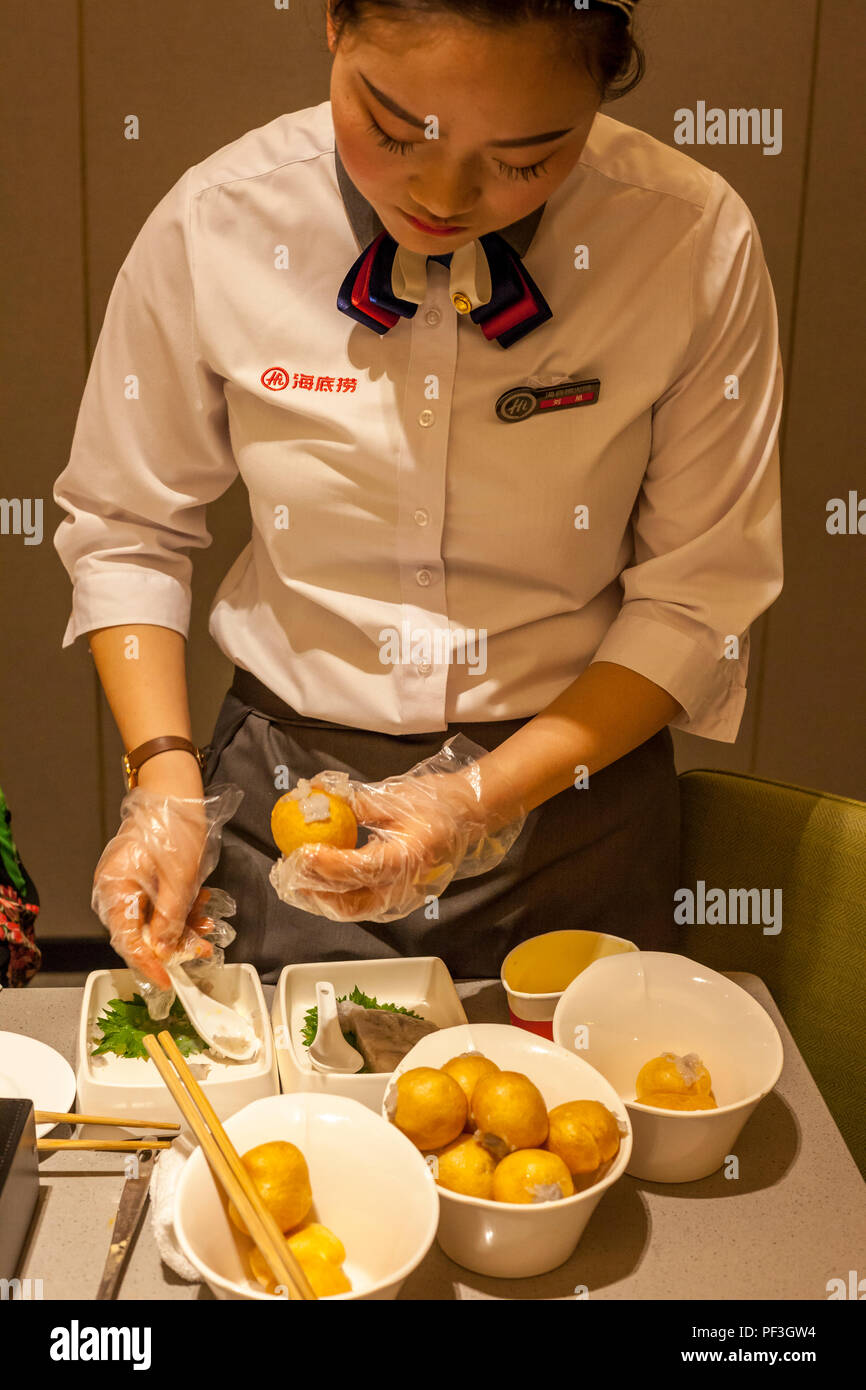 Nanjing, Jiangsu, China.  Waitress Making Gluten Balls  Stuffed with Eggs, Beef, Green Onions.  Haidilao Restaurant. Stock Photo