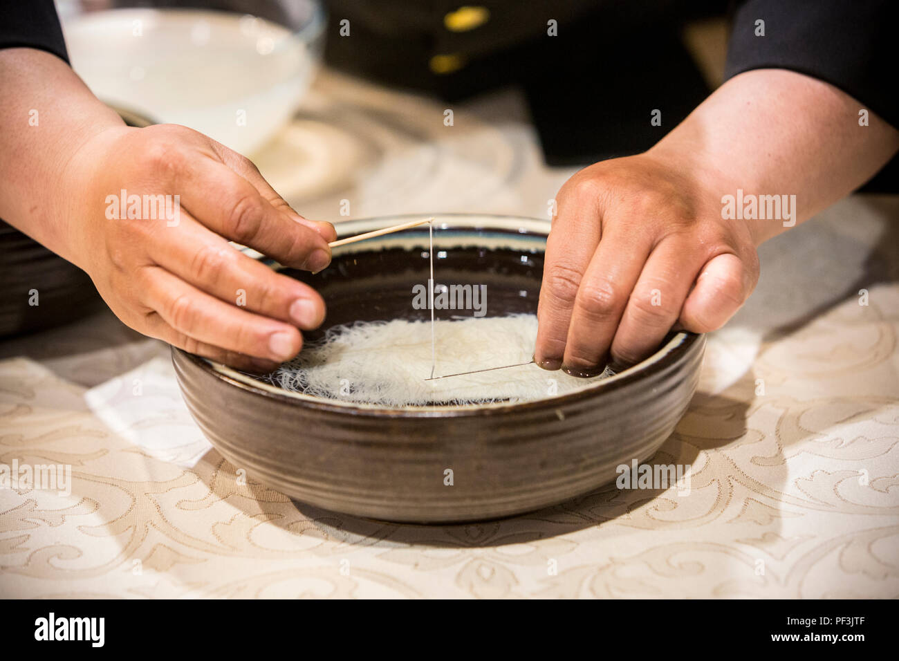 Yangzhou, Jiangsu, China.  Chinese Chef Washing Thread-thin Strips of Tofu. Stock Photo