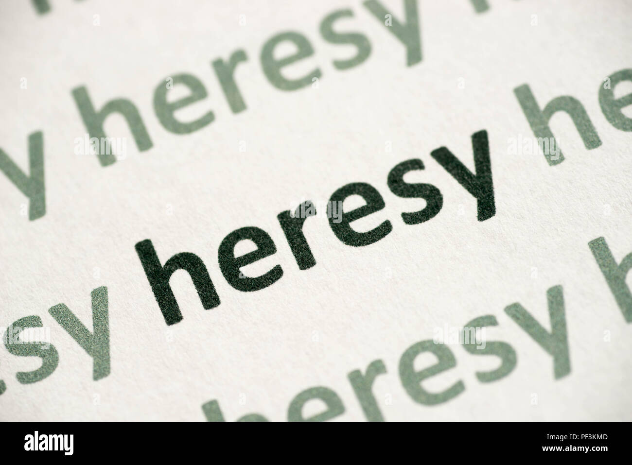 word heresy  printed on white paper macro Stock Photo