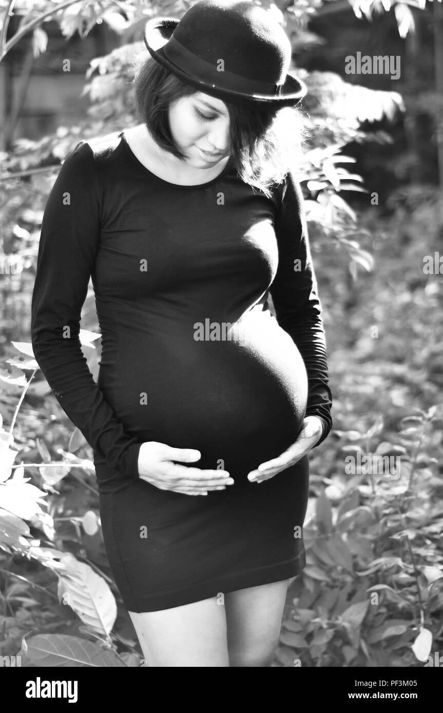 A pregnant woman holding her belly, Stock Photo
