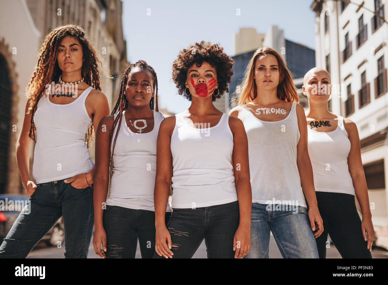 Group of female activists in dress code demonstrating outdoors. Protesting for women rights and equality. Stock Photo