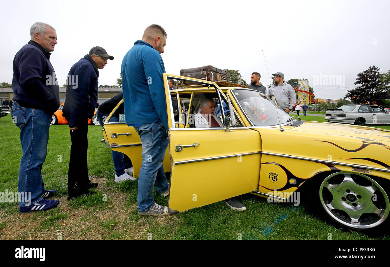Car enthusiasts view a customised 1972 Mercedes W114 during the London Cartel International Auto Show, at the South of England Showground, West Sussex, where over 2000 classic and retro cars are being showcased. Stock Photo