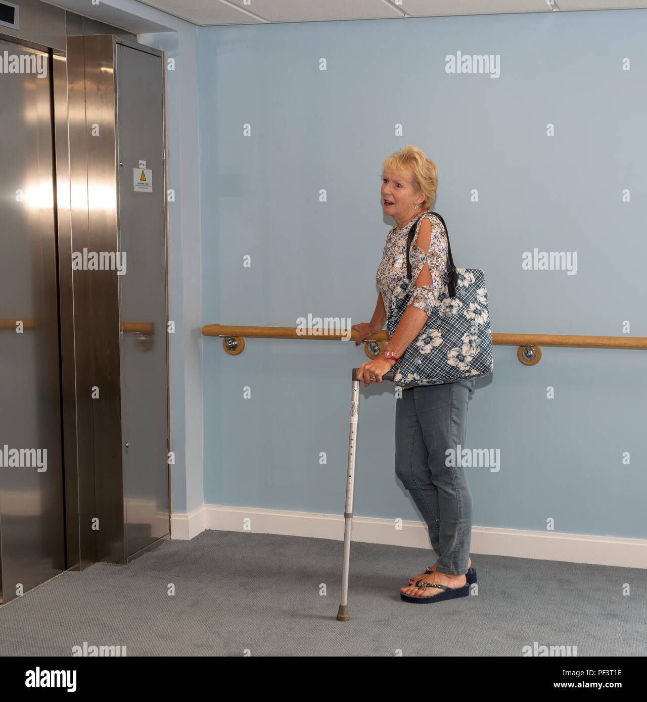 Elderly lady waiting to use a lift between floors Stock Photo Alamy