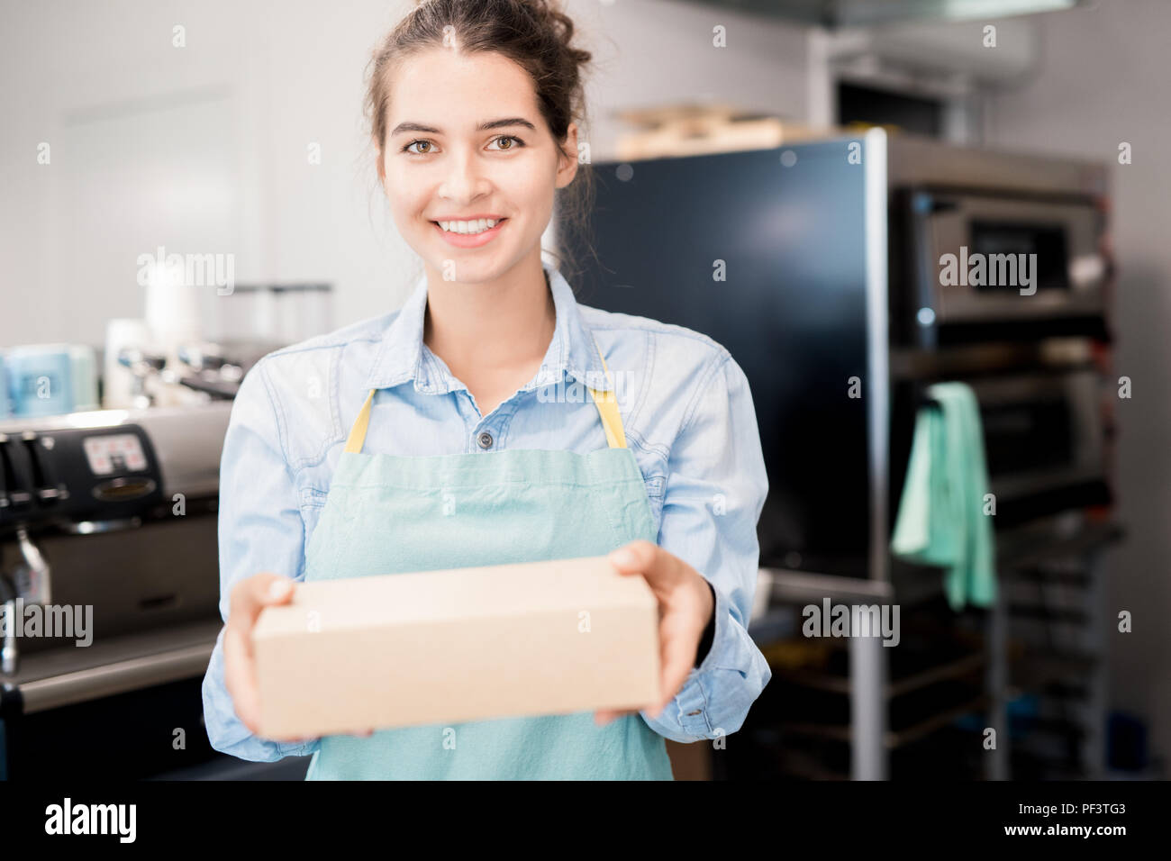 Smiling Shopkeeper Holding Box Stock Photo