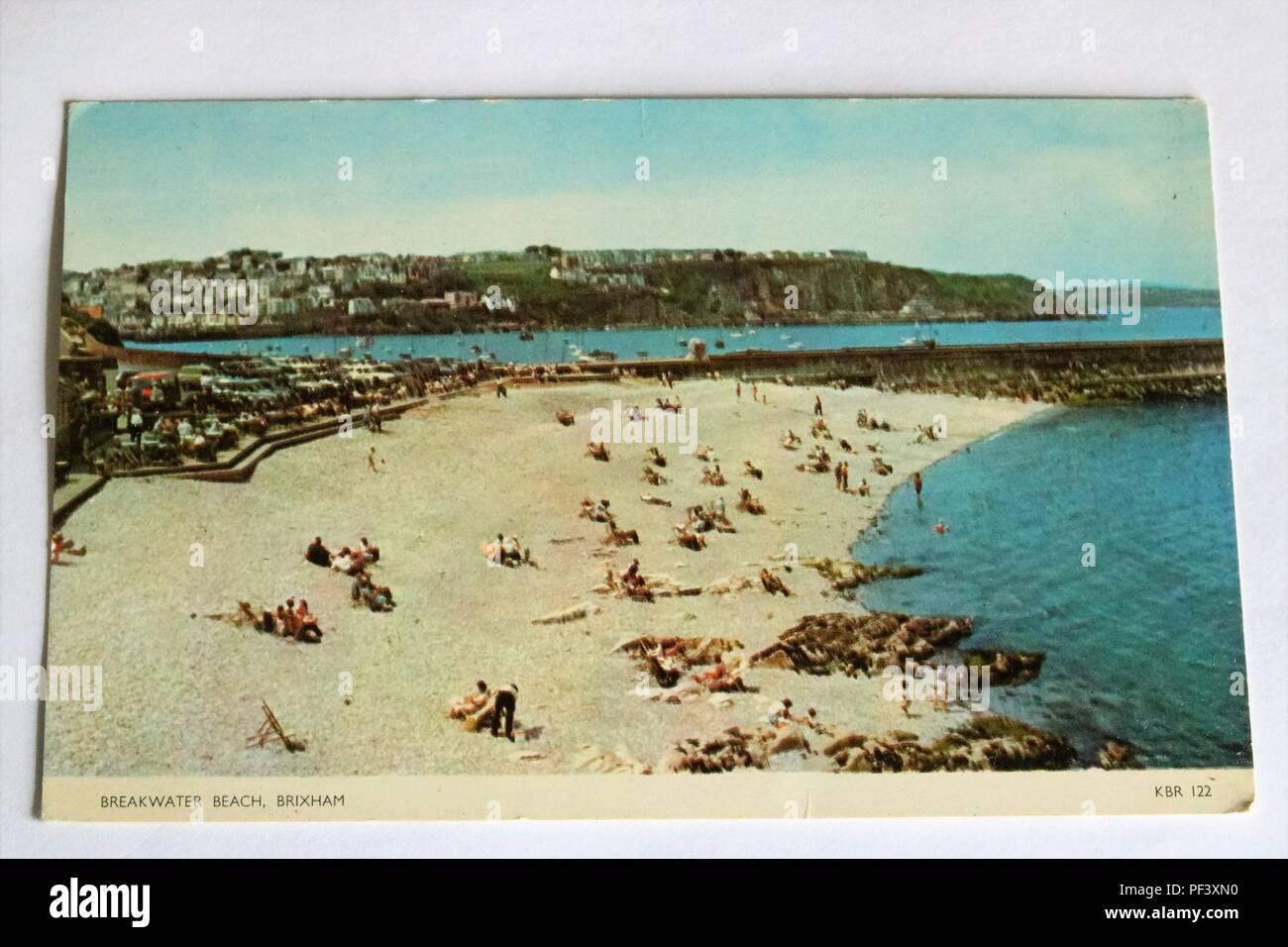 Early colour photo postcard showing Breakwater Beach, Brixham, Devon, UK with people sunbathing Stock Photo