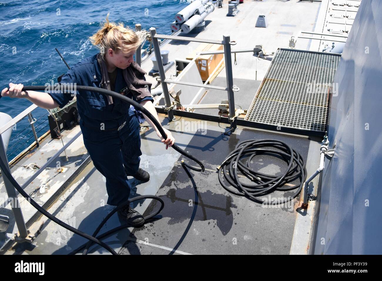 180813-N-RM440-1132 ARABIAN GULF (Aug. 13, 2018) Gas Turbine Systems Technician (Mechanical) 3rd Class Jillian Storey coils a hose after conducting a 72-hour gas turbine engine intake cleaning on the Arleigh-burke class missile-destroyer USS The Sullivans (DDG 68). The Sullivans is deployed to the U.S. 5th Fleet area of operations in support of naval operations to ensure maritime stability and security in the Central region, connecting the Mediterranean and the Pacific through the western Indian Ocean and three strategic choke points. (U.S. Navy photo by Mass Communication Specialist 2nd Class Stock Photo