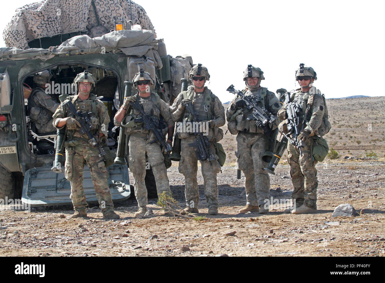 From left to right, Spc. Joshua Decker, Spc. Dylan Leonard, Sgt. Kevin Litz, Spc. Sam Garman, and Spc. William Reed, all infantrymen with Alpha Company, 2nd Battalion, 112th Infantry Regiment, 56th Stryker Brigade Combat Team, 28th Infantry Division, Pennsylvania Army National Guard, stand in front of a Stryker, an eight-wheeled armored fighting vehicle, shortly after concluding AT40 live-fire training at the National Training Center, Fort Irwin, California, Aug. 15. (U.S. Army National Guard photo by Sgt. Shane Smith/released) Stock Photo