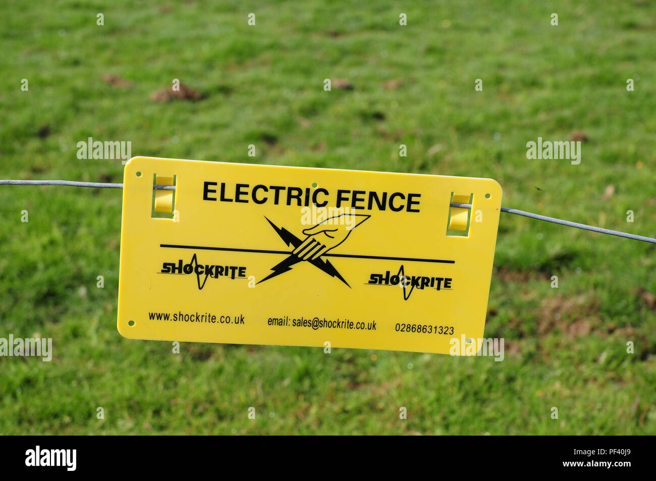 Notice warning of electrified fence. Stock Photo