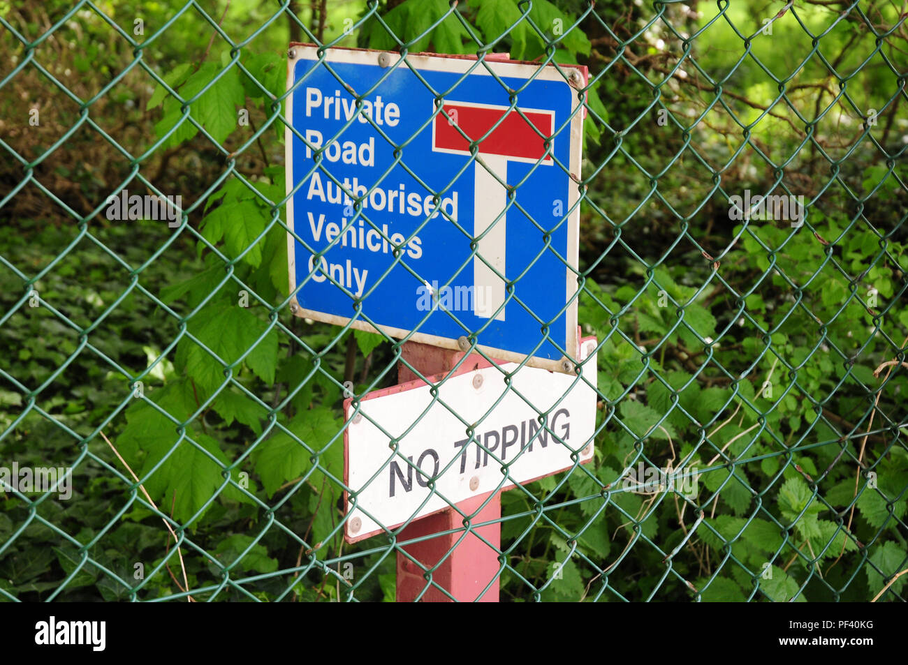 Notices on a country lane.  Chain link fencing.. Stock Photo