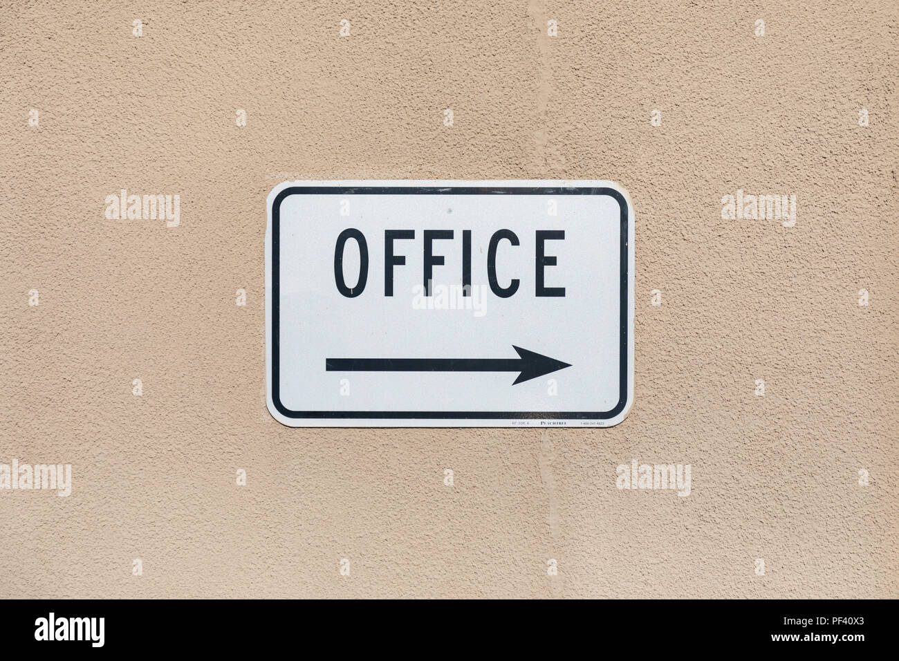 Office sign with right arrow, beige wall Stock Photo