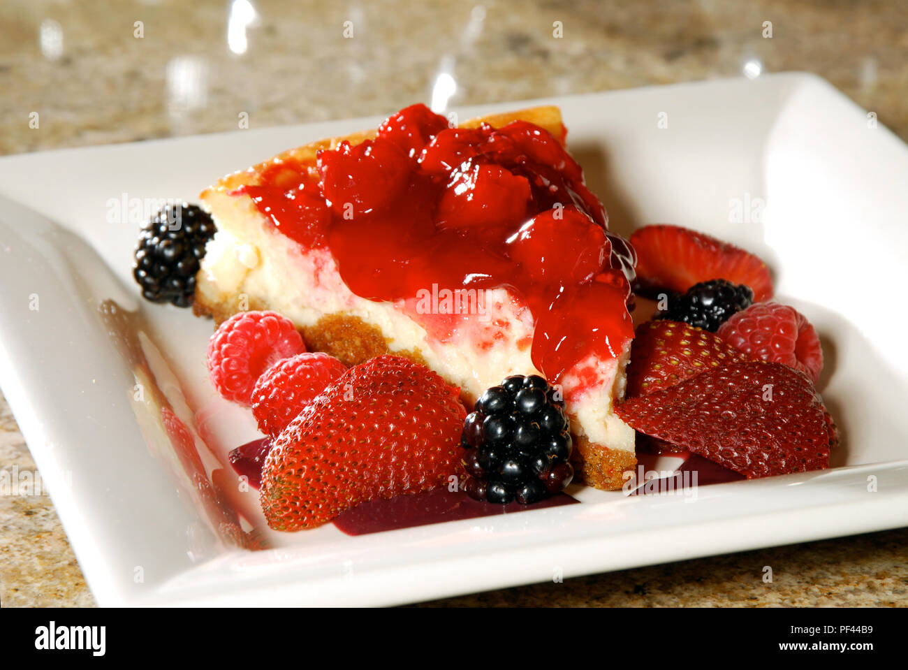 Royalty free stock photo of a slice of cheesecake with strawberries and blackberries.  Food stock photos. Stock Photo