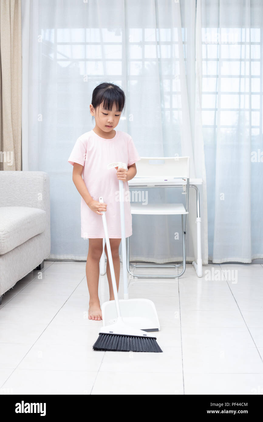 Asian Chinese little girl helping doing cleaning with broom and dustpan at  home Stock Photo - Alamy