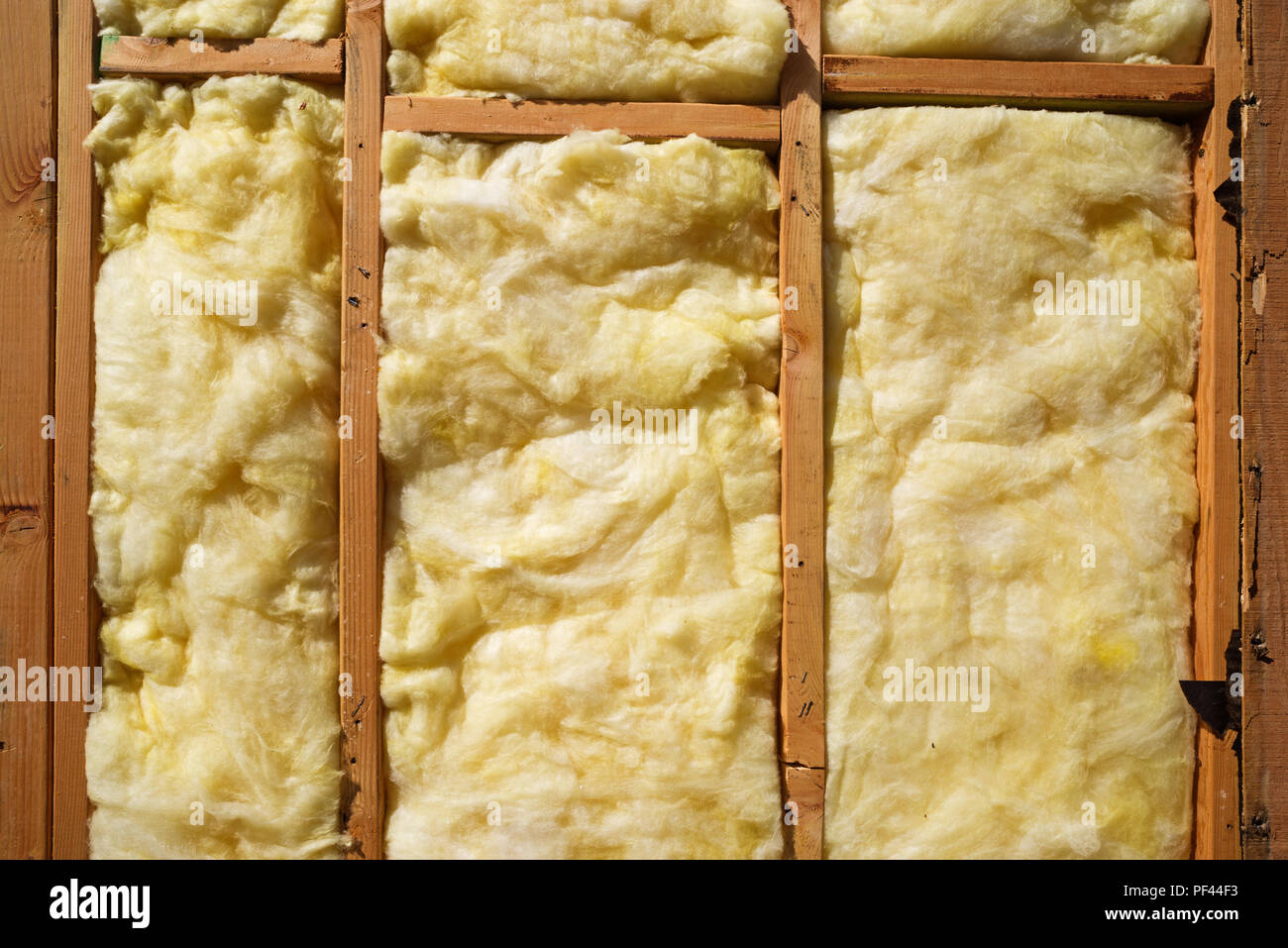 yellow fiberglass insulation in a wood framed wall Stock Photo Alamy