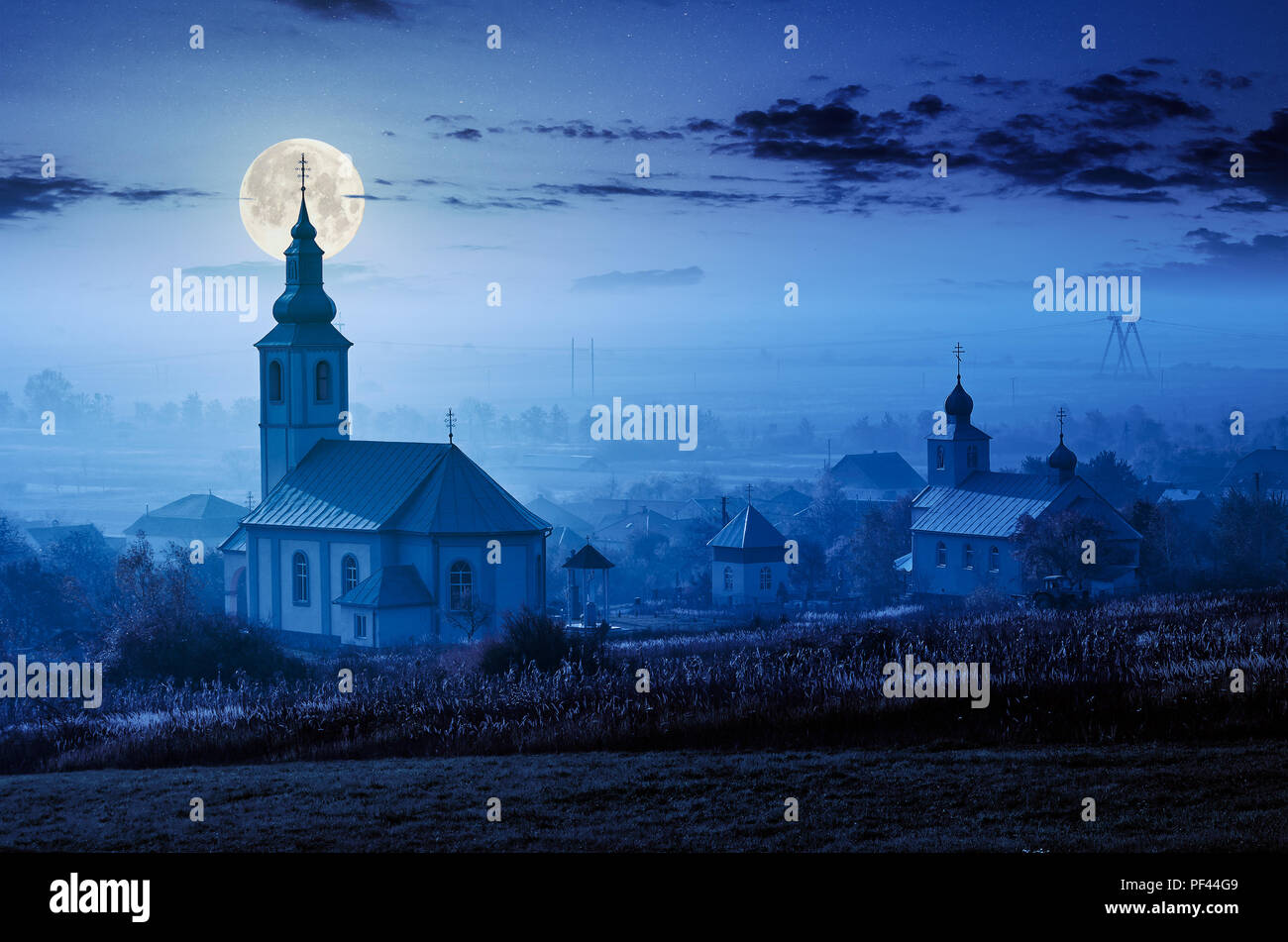 catholic and orthodox churches at foggy night in full moon light