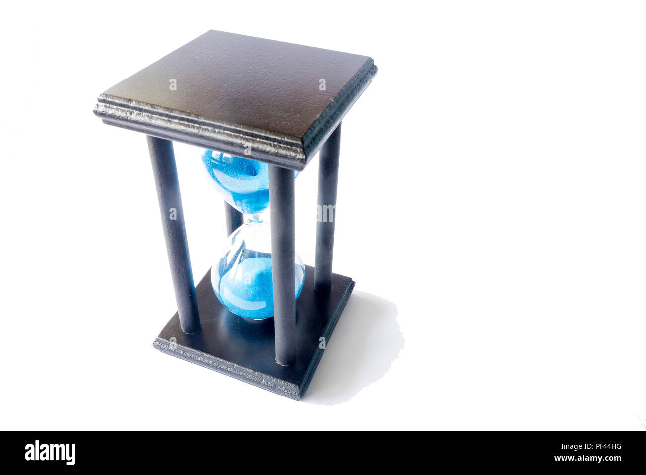 An elevated view of an hourglass against a white background. Stock Photo