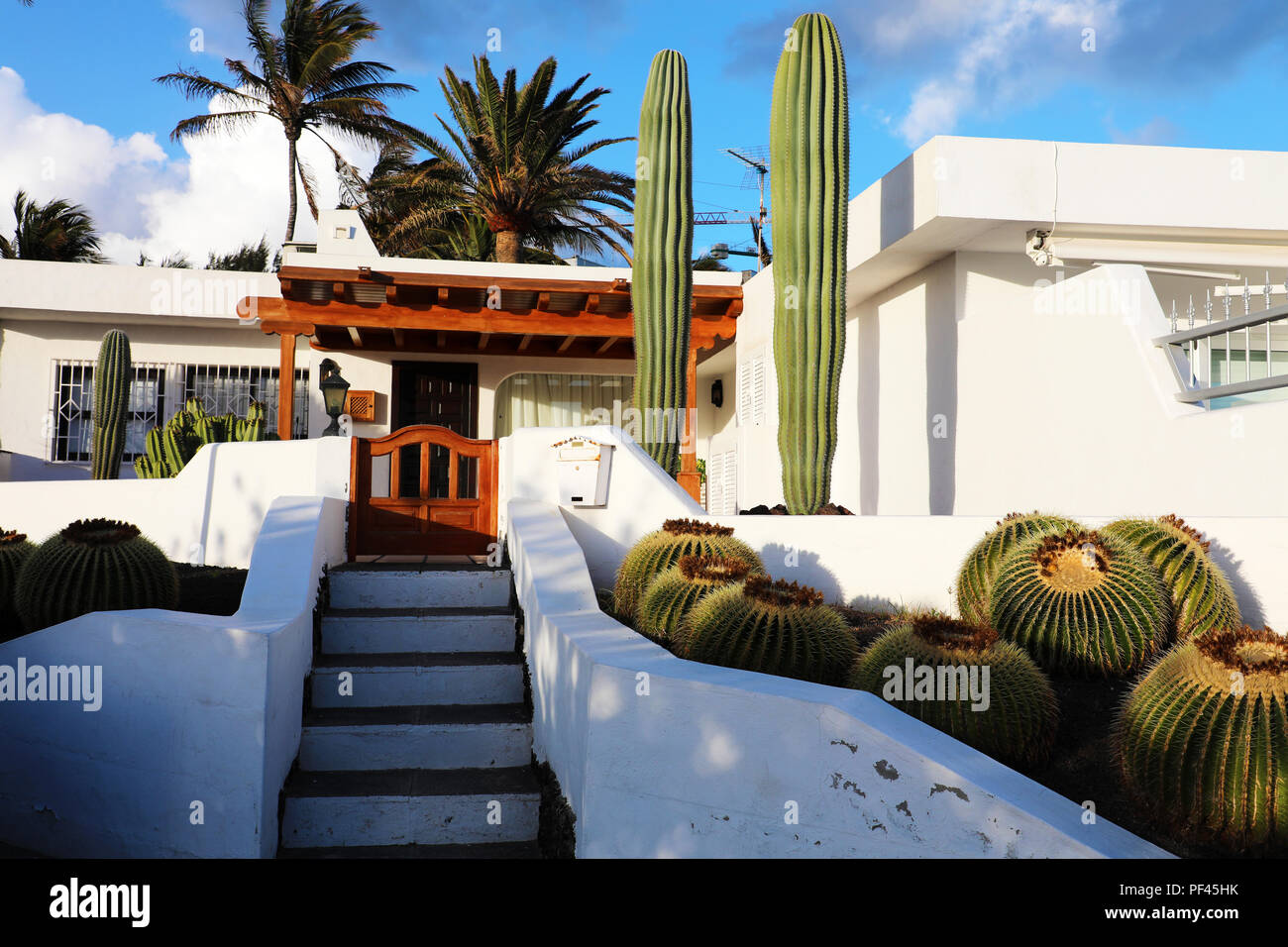 White modern house with cactus vegetation in Lanzarote Island, Spain. Summer vacation, travel destination, house rental concepts. Stock Photo