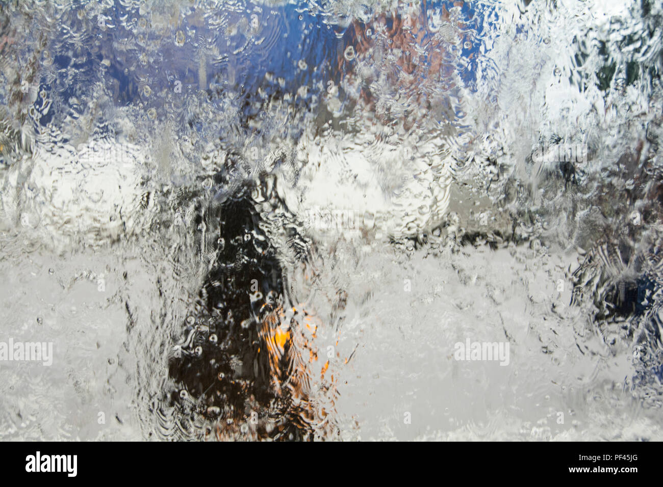 A woman walking in the rain - watery abstract background Stock Photo