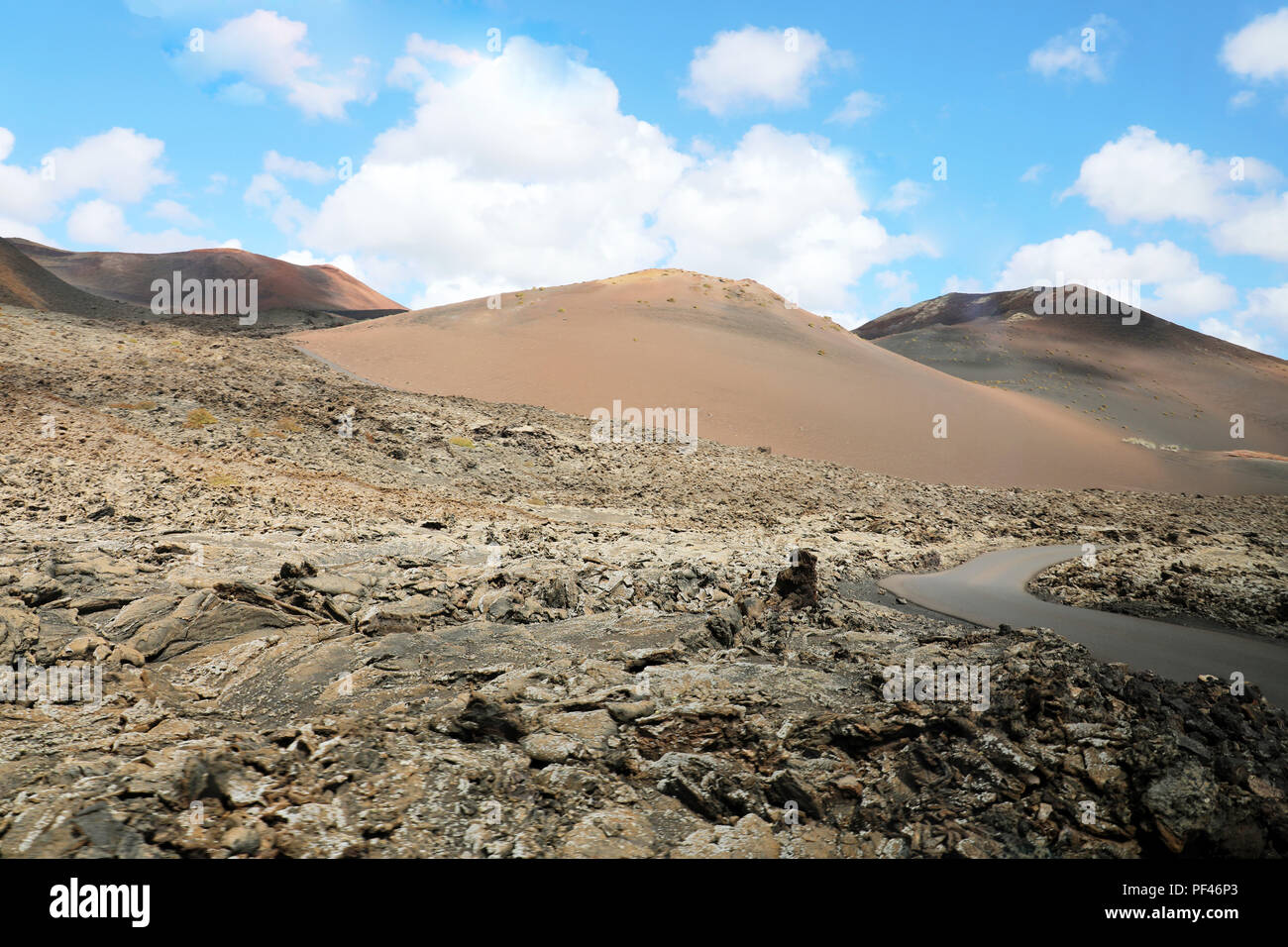 Solidified lava in Timanfaya National Park with red volcanos like martian landscape on the background, Lanzarote, Canary Islands Stock Photo