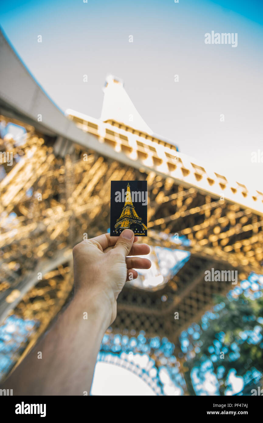 Hand holding ticket of Eiffel tower in front of the Eiffel Tower, Paris Stock Photo