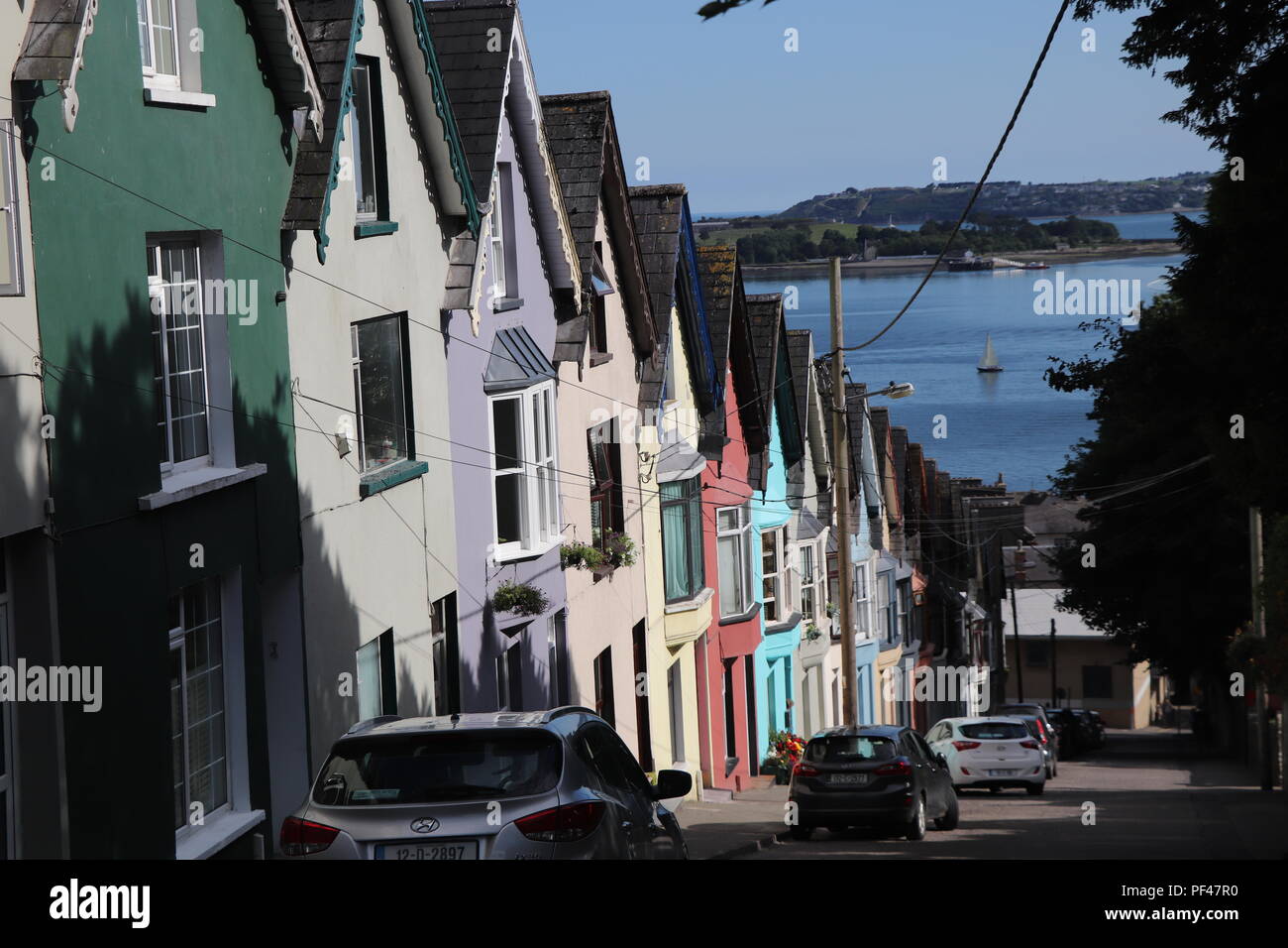 Colorful houses of Cobh, Ireland soaking the Irish summer sun. The symmetry is stunning and one of the best preserved parts in this little lovely town Stock Photo