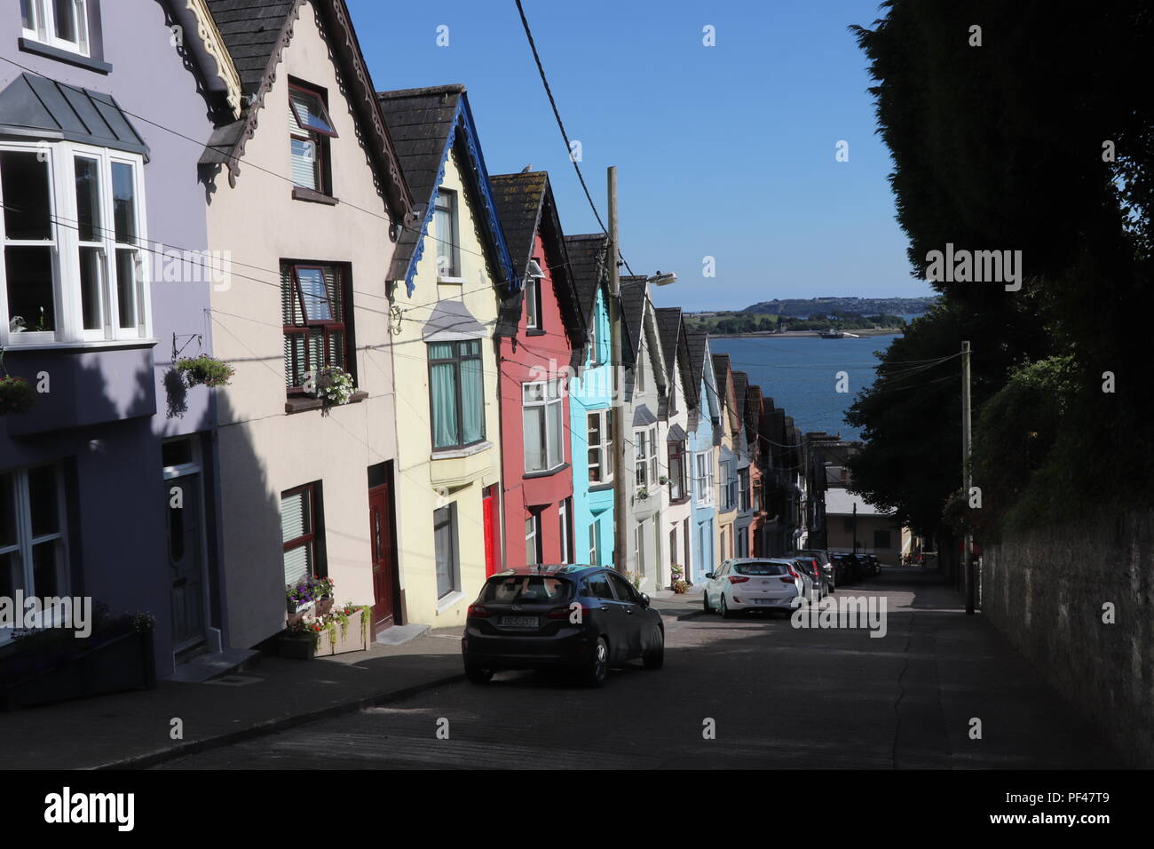 Colorful houses of Cobh, Ireland soaking the Irish summer sun. The symmetry is stunning and one of the best preserved parts in this little lovely town Stock Photo