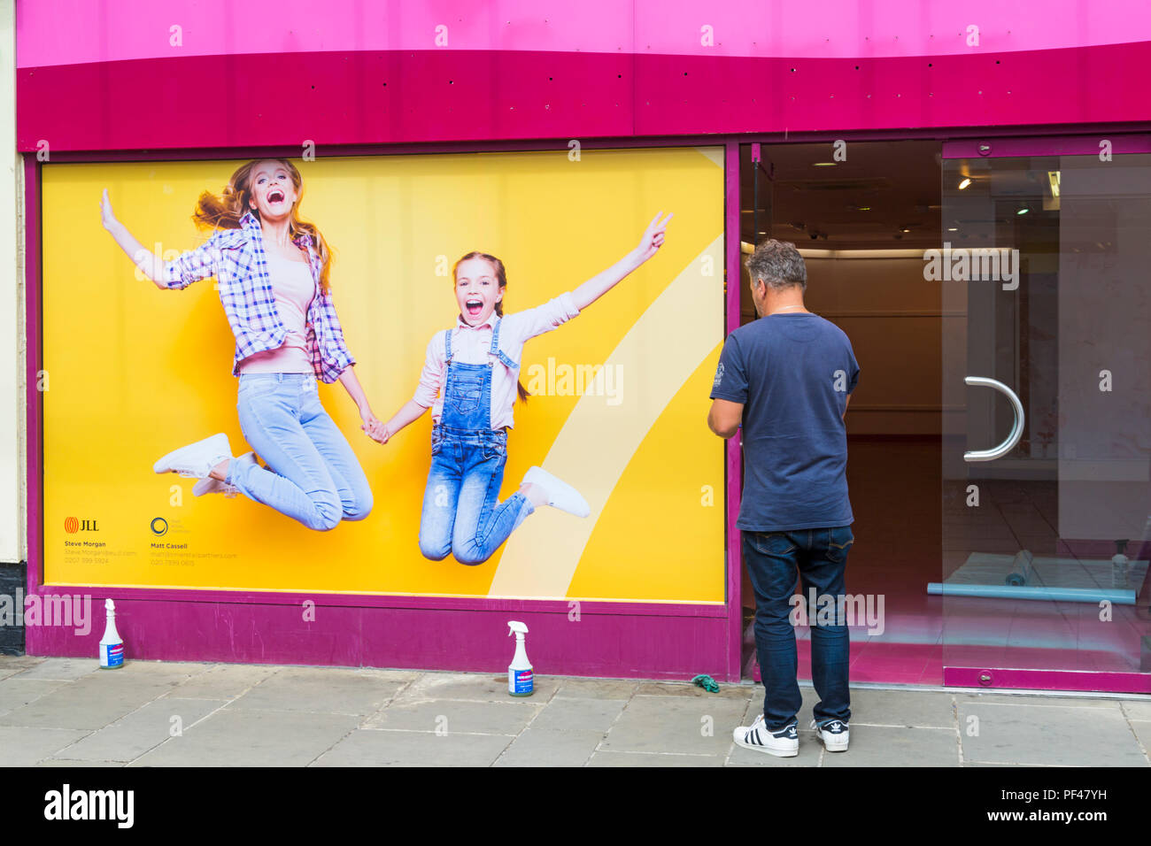 Man setting up window display in building at Salisbury, Wiltshire UK in