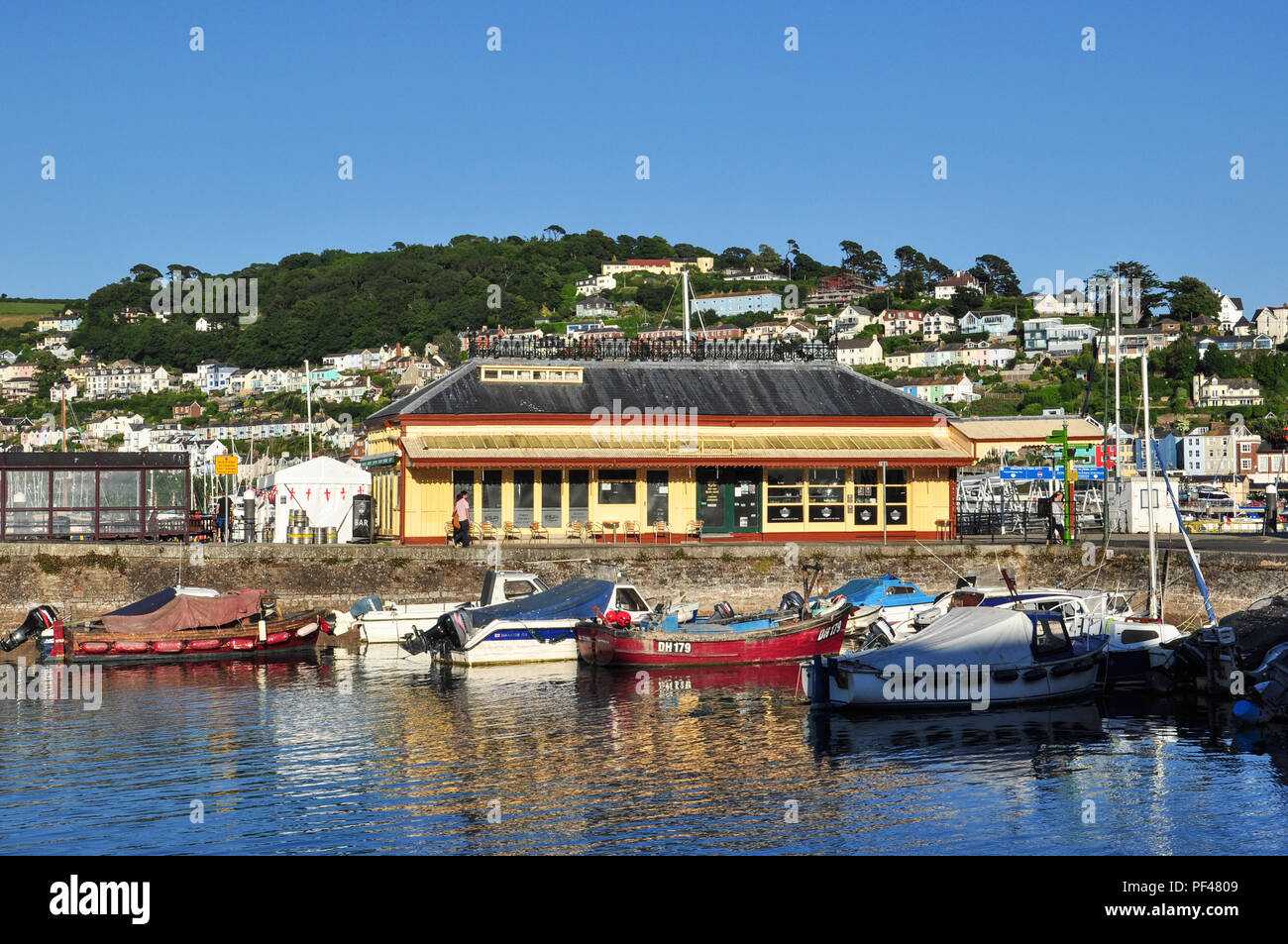 Old station building restaurant near the Boatfloat, Dartmouth (with Kingswear behind), South Devon, England, UK Stock Photo