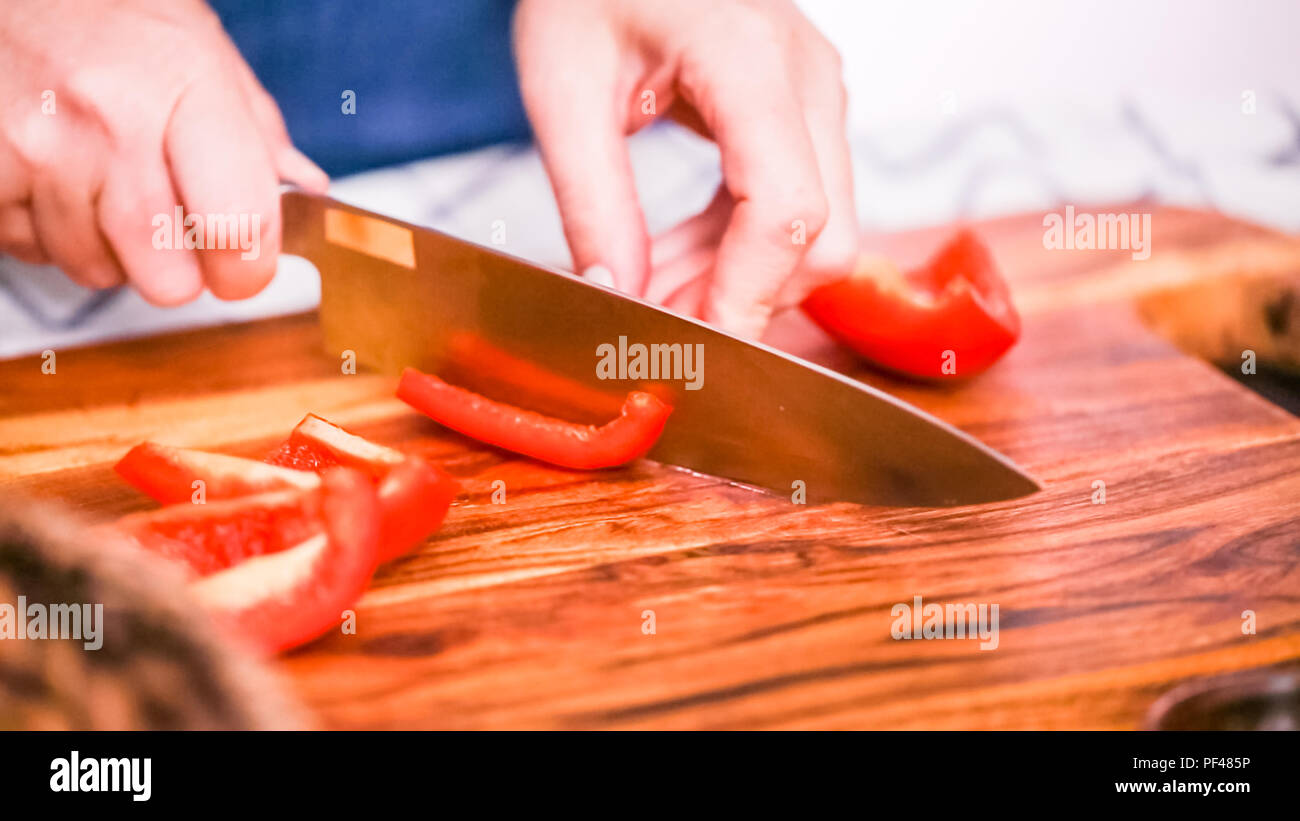 Step by step. Slicing red bell pepper on a wood cutting board Stock ...
